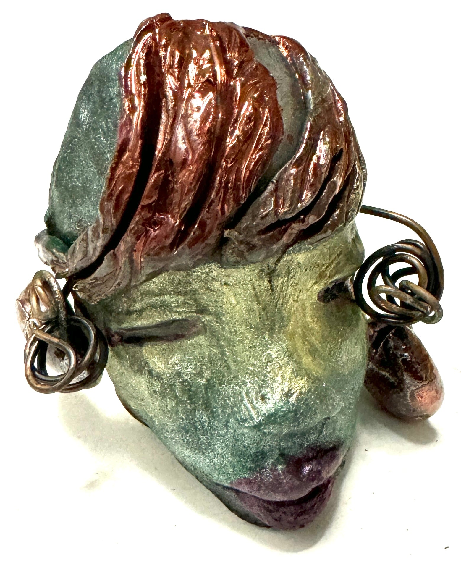 Monday weighs 3.2 oz and measures 3" by 4" in diameter. Her hair is copper-braided and her complexion is a light blueish green hue with purple lips. She is an ideal introductory piece from the HerDew mask collection.