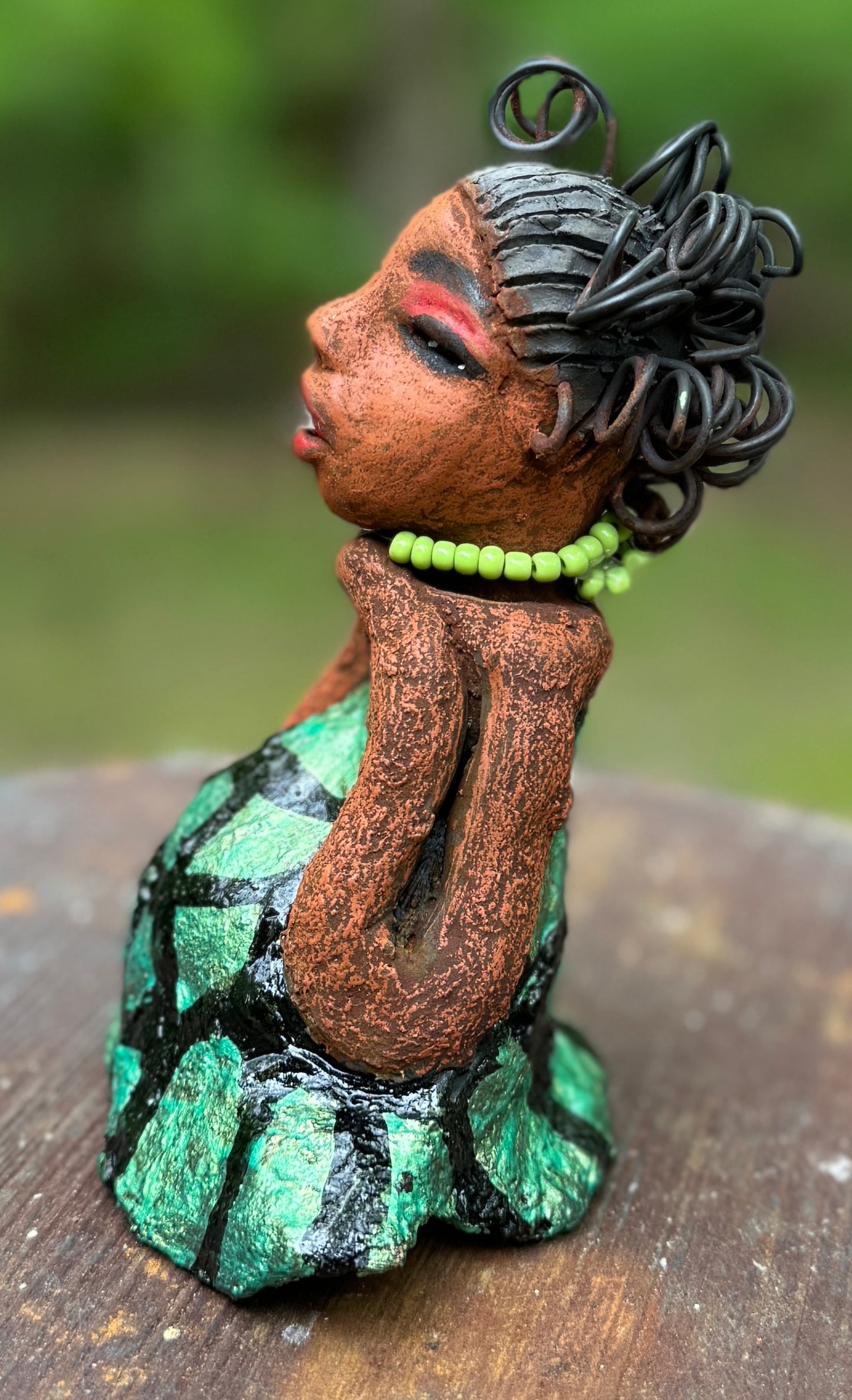 Introducing Mira, the fearless figurine measuring 6.5" x 3.5" x 3" and weighing only 13.5 ozs. Clad in a stunning black and green African print dress, with her coiled hair as her crown, Mira exudes audacity as she confidently rests her hands underneath her head in a yoga pose. Join the Herdew Collection and embark on a journey of excitement with our free shipping and customer-friendly return policy. Don't miss out on this one-of-a-kind treasure!