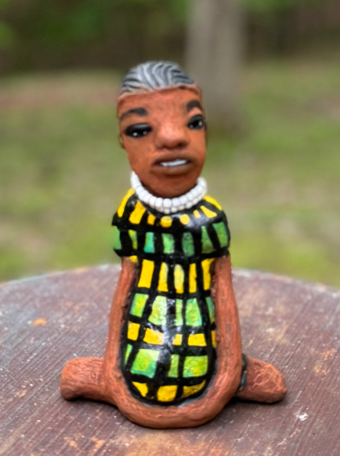 <p>Experience the bold and fearless Efia from the Herdew Collection! This raku fired sculpture stands tall at 6" x 4" x 3" and weighs a brave 10.44 ozs. Clothed in a striking yellow and green dress, Efia's coiled wire hair stretches over 1 foot. With confident outstretched arms, she strikes a yoga pose. Begin your collection with the captivating Efia and embrace adventure!</p> <p> </p>