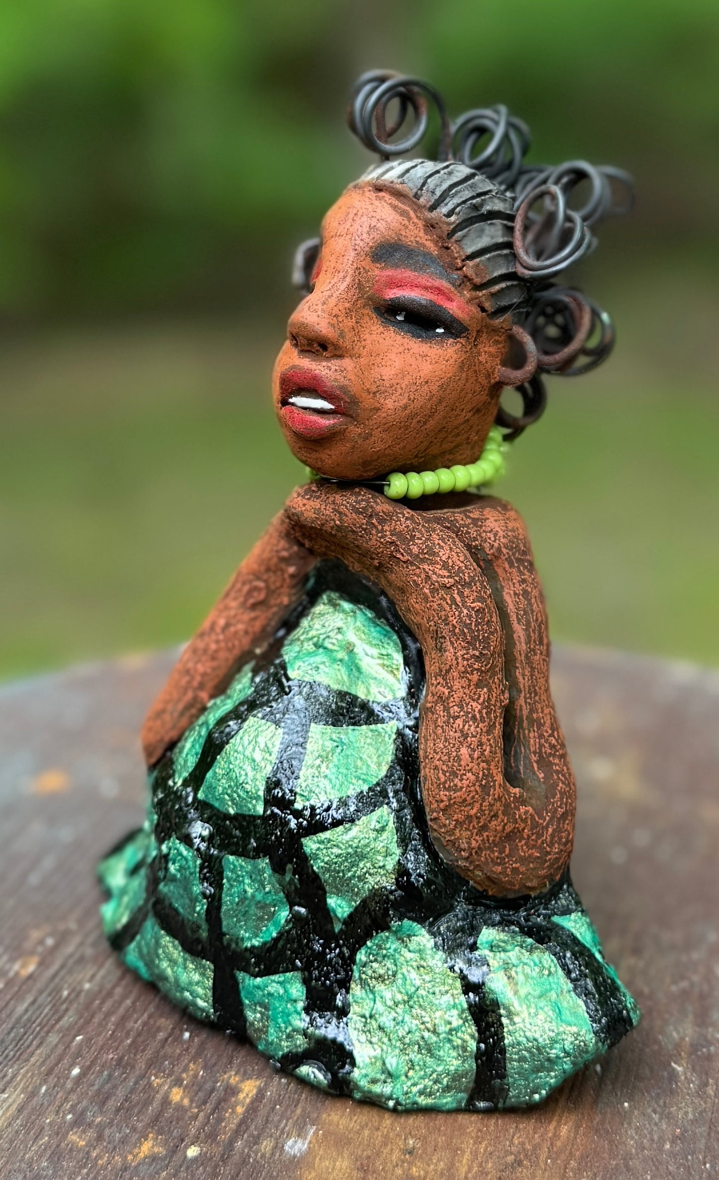 Introducing Mira, the fearless figurine measuring 6.5" x 3.5" x 3" and weighing only 13.5 ozs. Clad in a stunning black and green African print dress, with her coiled hair as her crown, Mira exudes audacity as she confidently rests her hands underneath her head in a yoga pose. Join the Herdew Collection and embark on a journey of excitement with our free shipping and customer-friendly return policy. Don't miss out on this one-of-a-kind treasure!