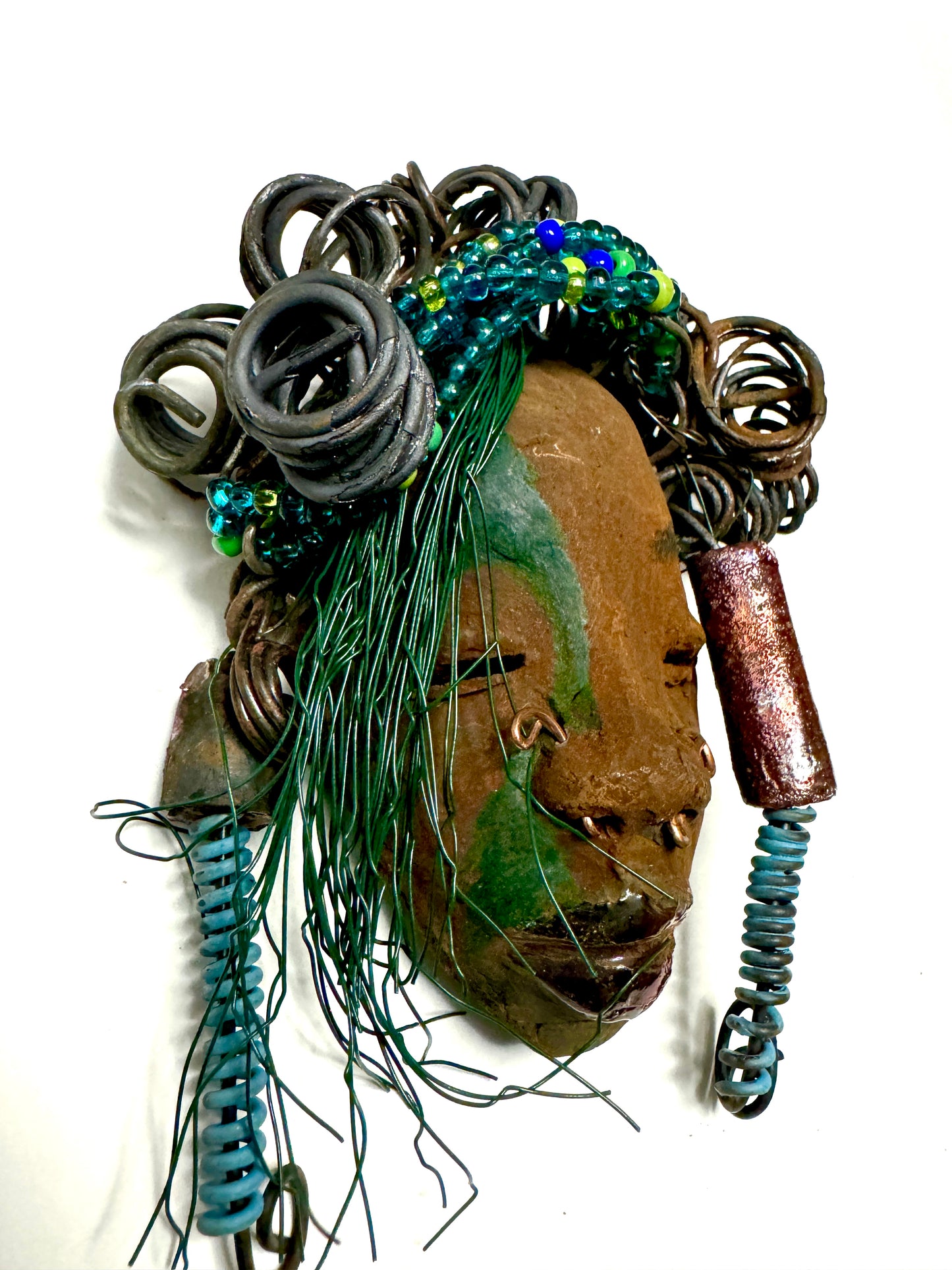 At 5" x 8" in size, Marcel makes a stunning addition to walls, trees, and shadow boxes. His signature brown and amber braided hair is ornamented with handcrafted Raku beads, while his skin has a warm honey brown hue. Each piece is equipped with over 10 16 & 24-gauge wire in the hair. This fashionable sculpture will bring a modern flair to any room - simply place it in a shadow box and enjoy!