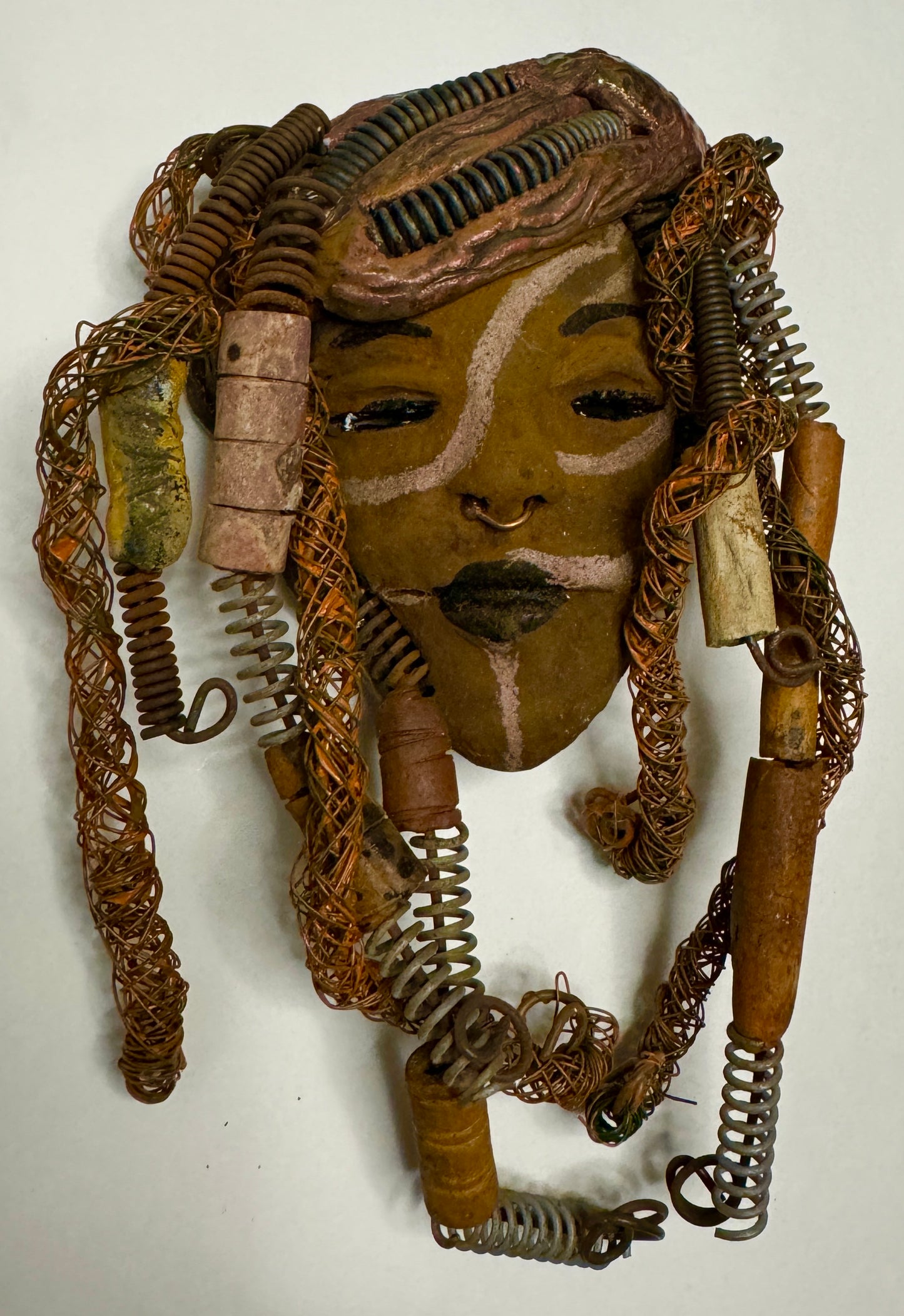 Weighing 6 oz and with a diameter of 5" by 8", Addo adds mystic to any wall, tree or shadowbox. His earthy braids, honey brown complexion and dark lips make him the perfect first piece from the HerDew mask collection. Shadow box not included with Jaleni's purchase.