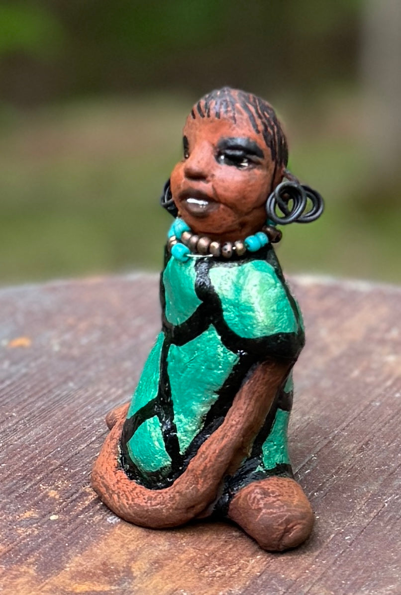Discover Nala, the bold figurine standing at 4.5" tall and weighing only 5.6 ozs, adorned in a striking black and green African print dress. With her hair styled in coils and her hands calmly resting under her head in a yoga pose, Nala emanates confidence. Join the Herdew Collection and embark on an exciting journey with our complimentary shipping and customer-friendly return policy. Don't hesitate to claim this unique treasure!