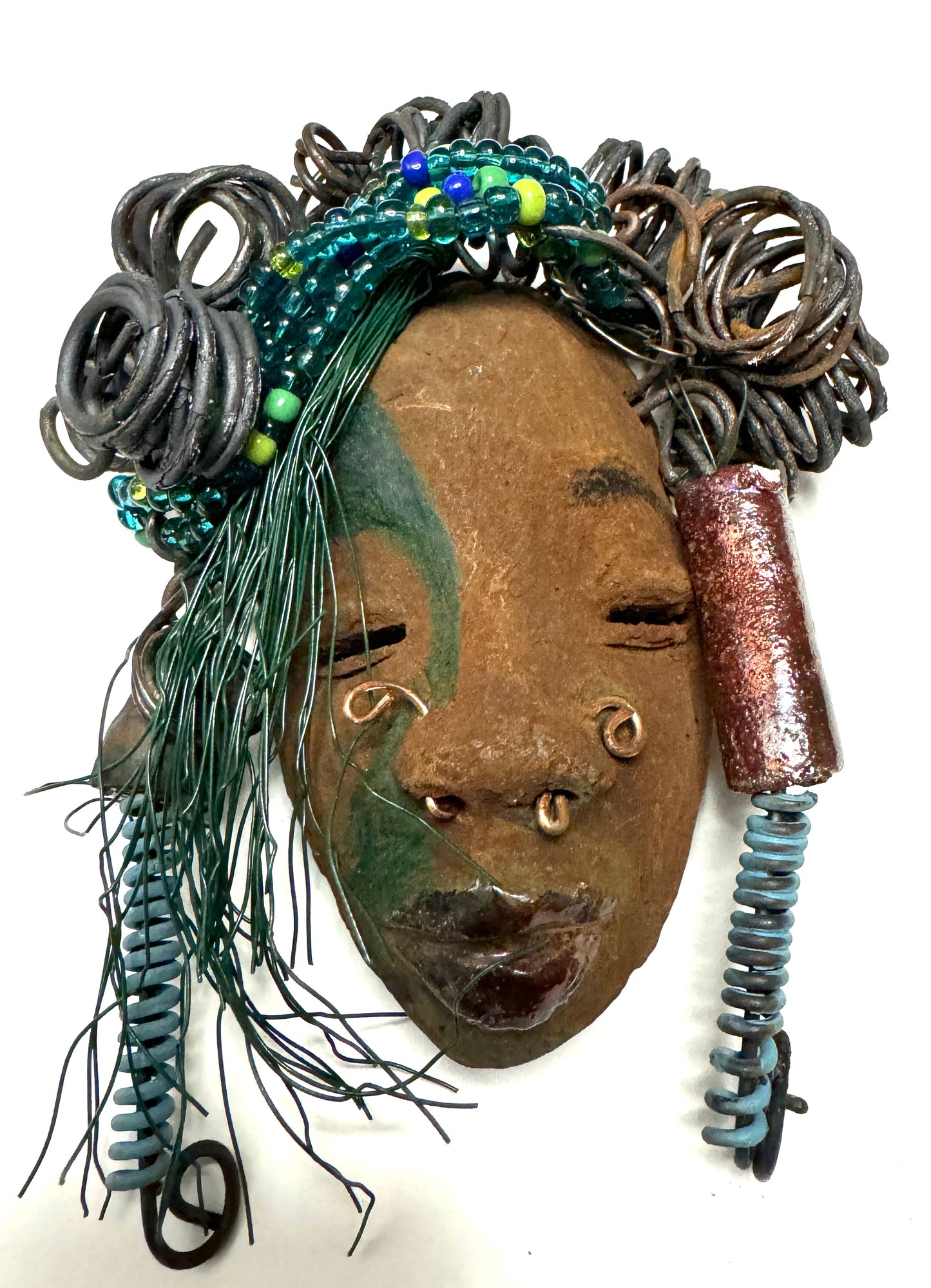 At 5" x 8" in size, Marcel makes a stunning addition to walls, trees, and shadow boxes. His signature brown and amber braided hair is ornamented with handcrafted Raku beads, while his skin has a warm honey brown hue. Each piece is equipped with over 10 16 & 24-gauge wire in the hair. This fashionable sculpture will bring a modern flair to any room - simply place it in a shadow box and enjoy!