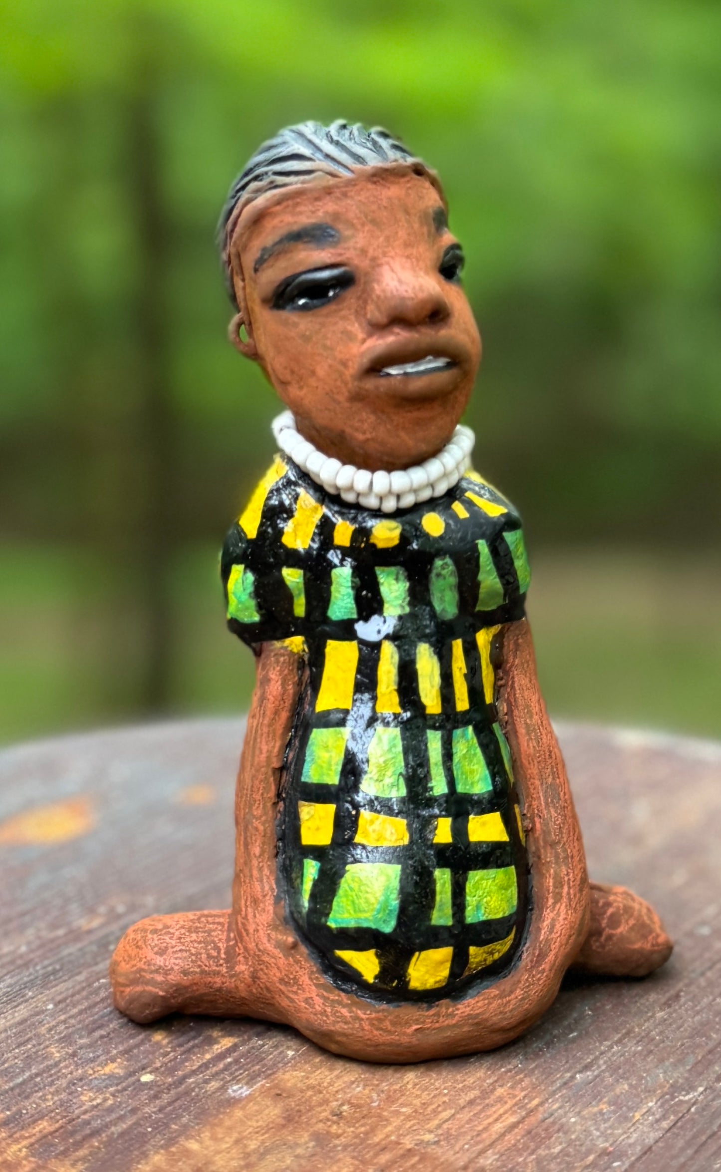 <p>Experience the bold and fearless Efia from the Herdew Collection! This raku fired sculpture stands tall at 6" x 4" x 3" and weighs a brave 10.44 ozs. Clothed in a striking yellow and green dress, Efia's coiled wire hair stretches over 1 foot. With confident outstretched arms, she strikes a yoga pose. Begin your collection with the captivating Efia and embrace adventure!</p> <p> </p>