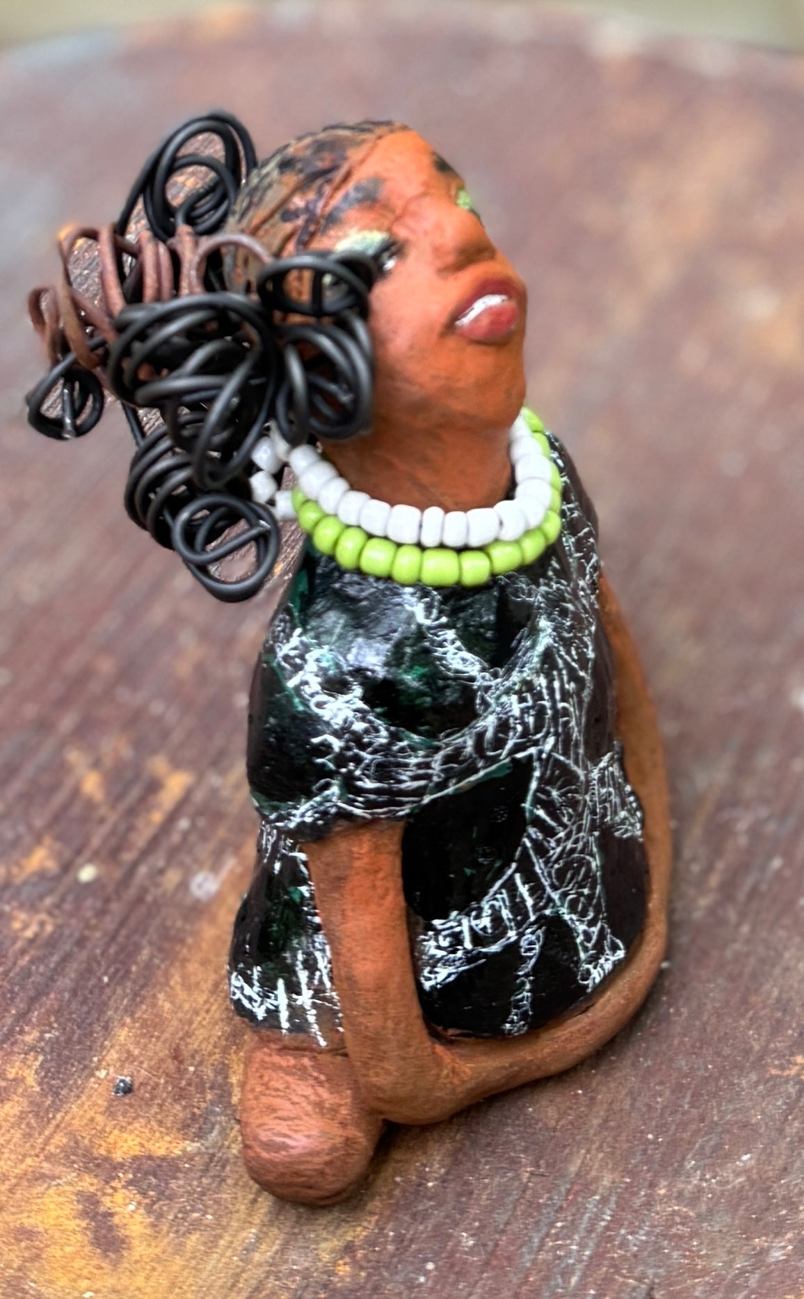 Say hello to Salana, the daring figurine standing at 4.5" x 3.5" x 3" and weighing a mere 8.5 ozs. Adorned in a striking black and white African print dress and with her coiled hair as her crown, Salana exudes boldness with her head held back and bravery as she sits in a yoga pose, radiating confidence. Embark on an adventure with the Herdew Collection and feel the exhilaration of free shipping and our customer-friendly return policy. Don't let this unique piece slip away!