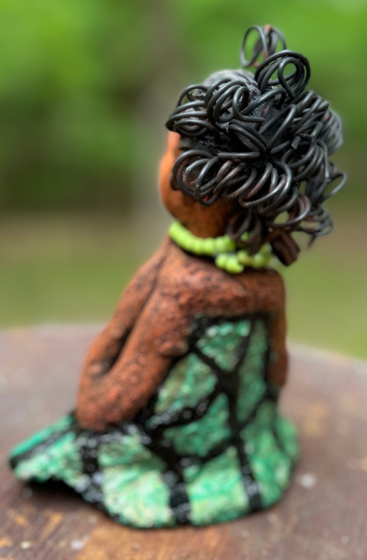 Introducing Mira, the fearless figurine measuring 6.5" x 3.5" x 3" and weighing only 13.5 ozs. Clad in a stunning black and green African print dress, with her coiled hair as her crown, Mira exudes audacity as she confidently rests her hands underneath her head in a yoga pose. Join the Herdew Collection and embark on a journey of excitement with our free shipping and customer-friendly return policy. Don't miss out on this one-of-a-kind treasure!