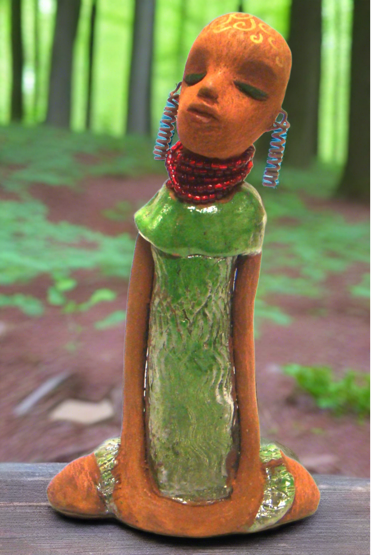 <span>Measuring 10" x 6" x 2.5" and weighing 1.03 lbs, Amaya has a honey brown complexion, with tribal patterns drawn in spirals and gold ink. Her alligator green dress is accented by ruby red beads and spiral wire earrings. A sophisticated addition to your home, Amaya also comes with free shipping - plus, got questions? Ask away!</span> <p> </p>