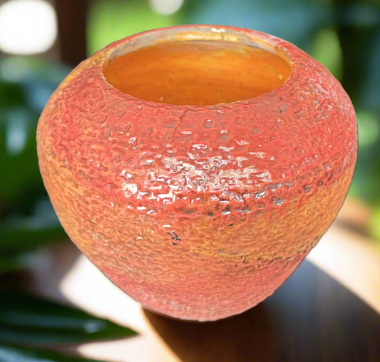 This textured orange and gold vase adds a unique touch to any space. With a 4 inch height and 6 inch width and depth, this 1 pound and 2 ounce vase is the perfect size for displaying flowers or other decorative items. The unglazed interior adds to its natural and rustic charm.