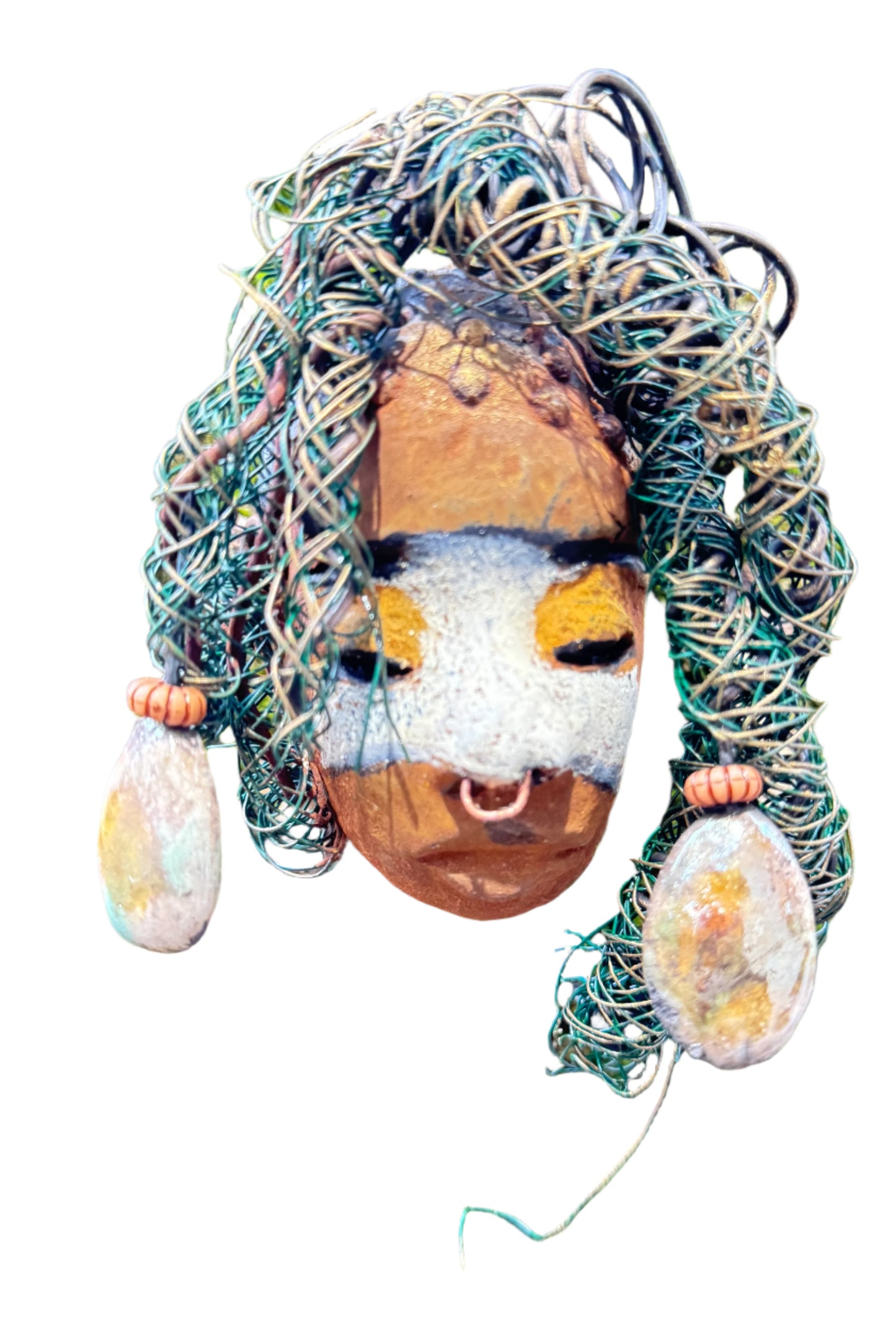 Alison is a 3” x 5” 5oz. mixed media raku fire mask with 15 feet of 24 and 16 gauge wire. Featuring a copper nose ring and three-colored complexion, this piece has two large Raku fired earrings with a wooden bead. Alison looks stunning with a mossy tree background and would make a lovely addition to your HerDew mask collection.