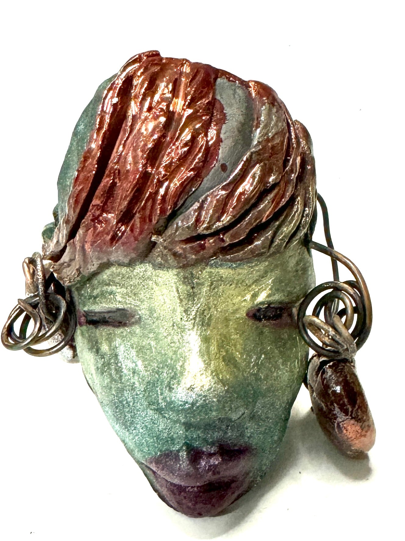 Monday weighs 3.2 oz and measures 3" by 4" in diameter. Her hair is copper-braided and her complexion is a light blueish green hue with purple lips. She is an ideal introductory piece from the HerDew mask collection.
