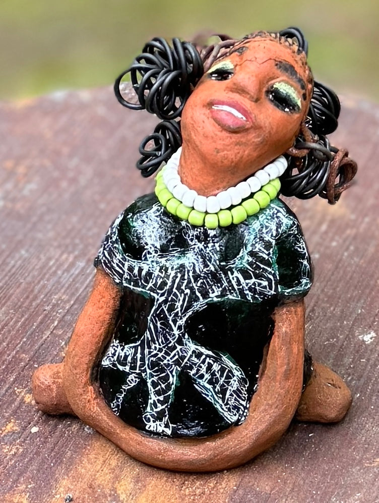 Say hello to Salana, the daring figurine standing at 4.5" x 3.5" x 3" and weighing a mere 8.5 ozs. Adorned in a striking black and white African print dress and with her coiled hair as her crown, Salana exudes boldness with her head held back and bravery as she sits in a yoga pose, radiating confidence. Embark on an adventure with the Herdew Collection and feel the exhilaration of free shipping and our customer-friendly return policy. Don't let this unique piece slip away!