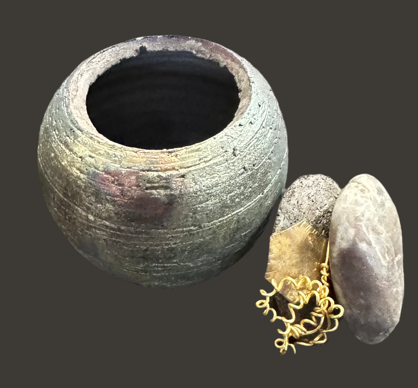 Explore the intricate features of this dark iridescent pottery piece, measuring 4 inches tall and 3 inches wide and deep with a 2-inch opening. The lid boasts an earthy rock accent and features brass and spiral brass wire.