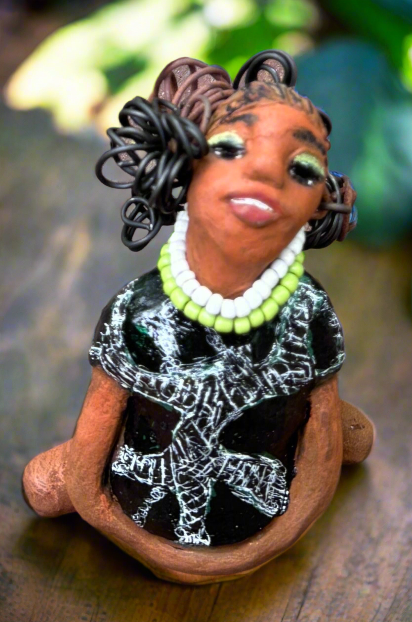 Say hello to Salana, the daring figurine standing at 4.5" x 3.5" x 3" and weighing a mere 8.5 ozs. Adorned in a striking black and white African print dress and with her coiled hair as her crown, Salana exudes boldness with her head held back and bravery as she sits in a yoga pose, radiating confidence. Embark on an adventure with the Herdew Collection and feel the exhilaration of free shipping and our customer-friendly return policy. Don't let this unique piece slip away!
