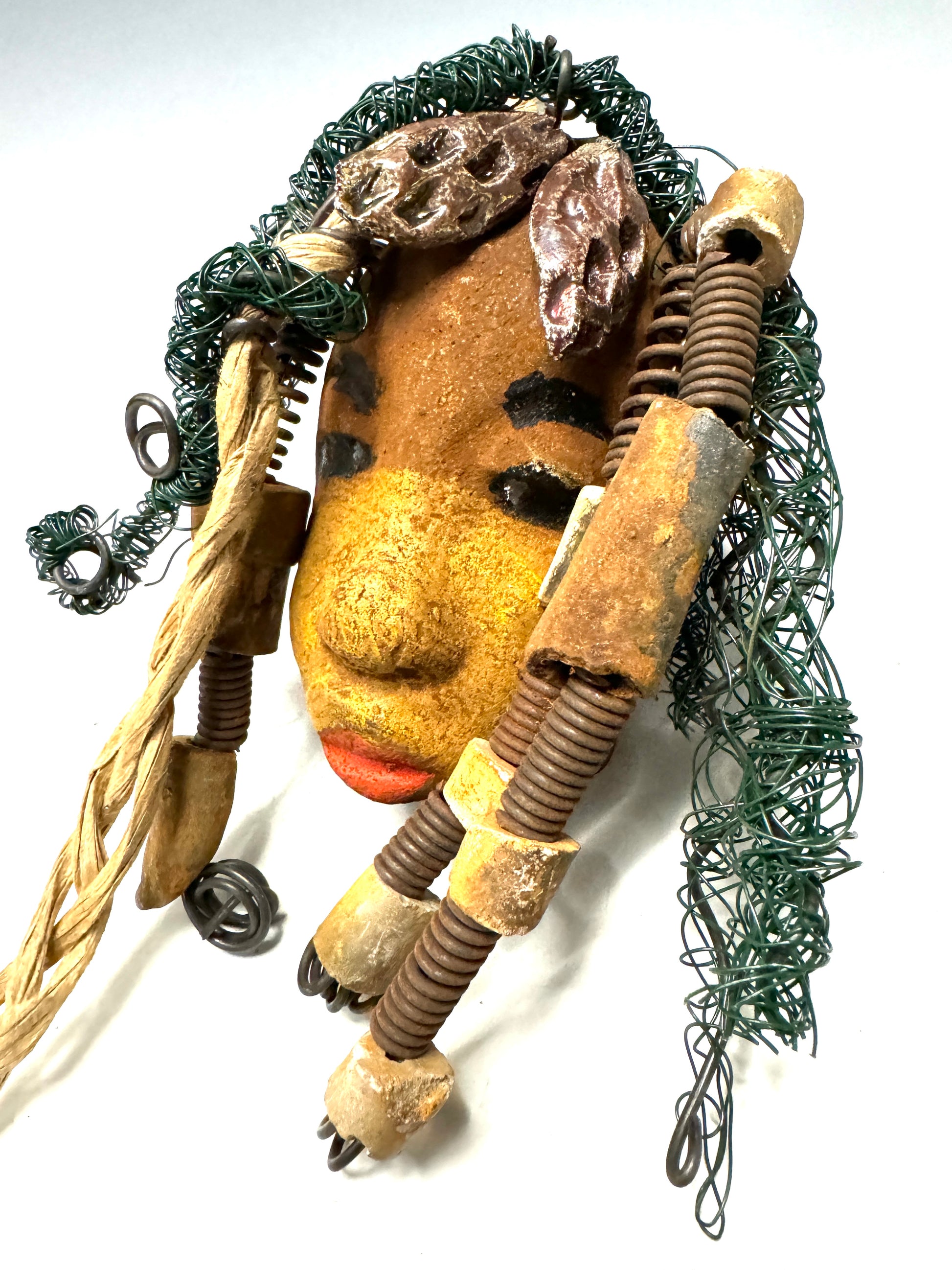 Wanda is a 5" x 8" Raku-fired mask, featuring 16 and 24-gauge wire over 20ft in length. Her two tone honey brown complexion is the perfect contrast to her green-coiled locs. Get her this holiday season at a discount, making it the perfect time to start a collection or gift her as a special surprise.