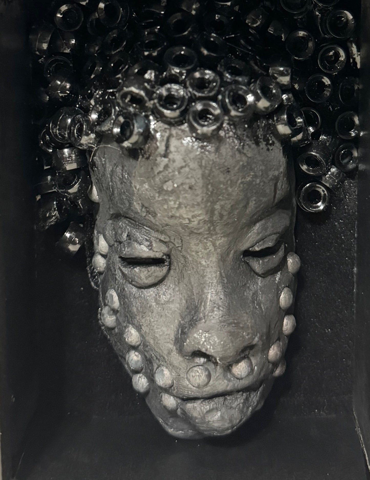 Randy is a mask that is raku fired and is enclosed in a 4“ x 4“ black shadowbox. He has over 50 pony beads as hair. He has over 50 pony beads as hair!