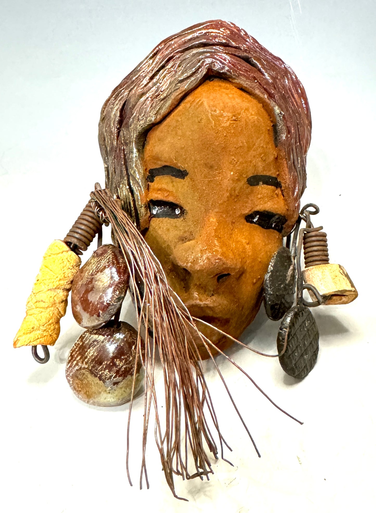 Marci boasts a beautiful honey-brown complexion, standing 5" x 7" weighs 6.2 ozs. and embellished with coils of wire and hand-made beads. Her hair is graced with a copper glaze and was photographed outside amongst the trees. But of course, she will look fantastic no matter where you decide to place her.