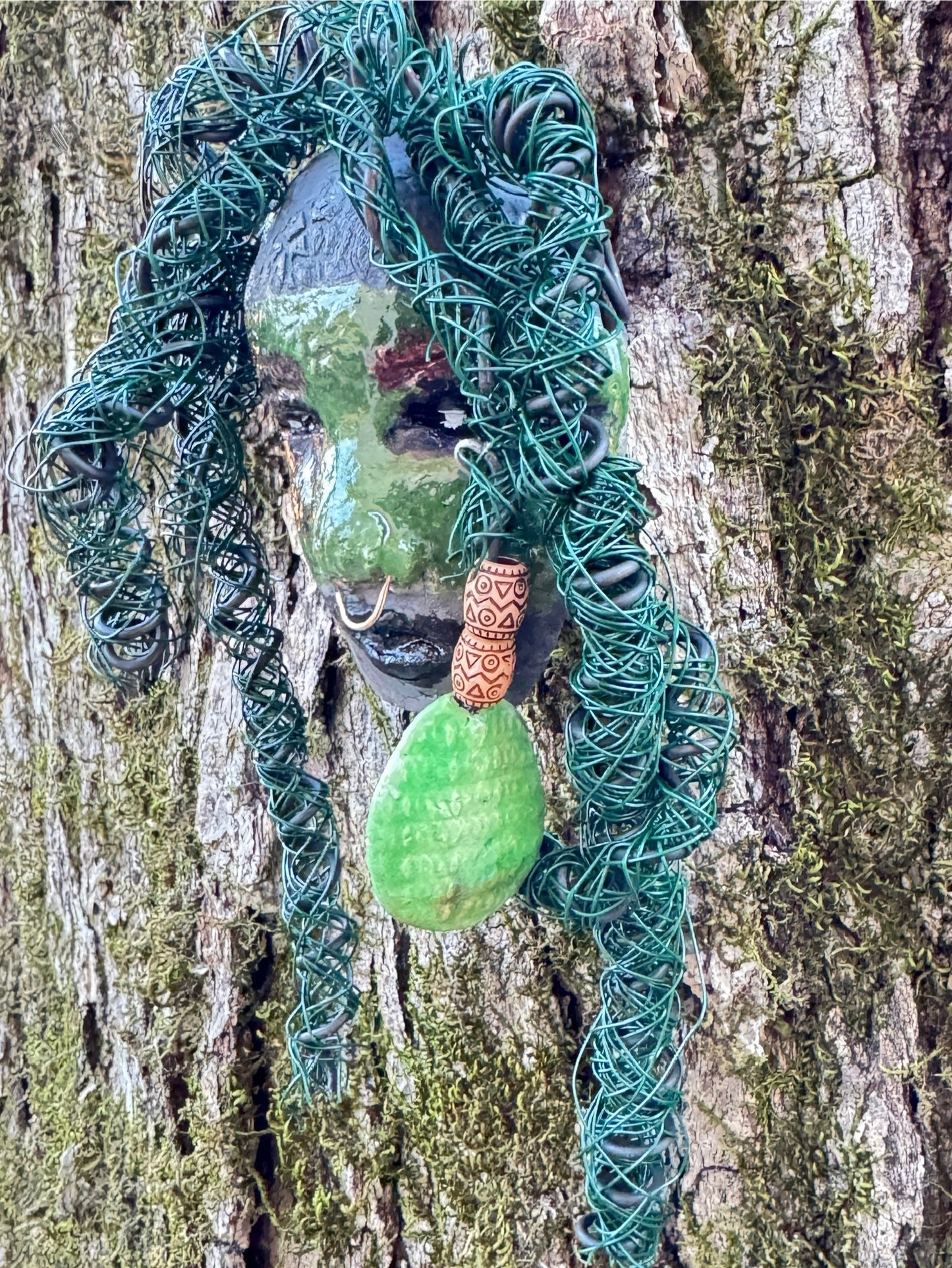 Introducing Nala, a unique raku fire mask made with a stunning mixture of 24 and 16 gauge wire and adorned with detailed blue tribal beads. This 4 x 6" piece features over 15 feet of wire and can be proudly displayed on a solid black or white surface. For a more striking display, try Nala against a backdrop of lush, verdant trees.