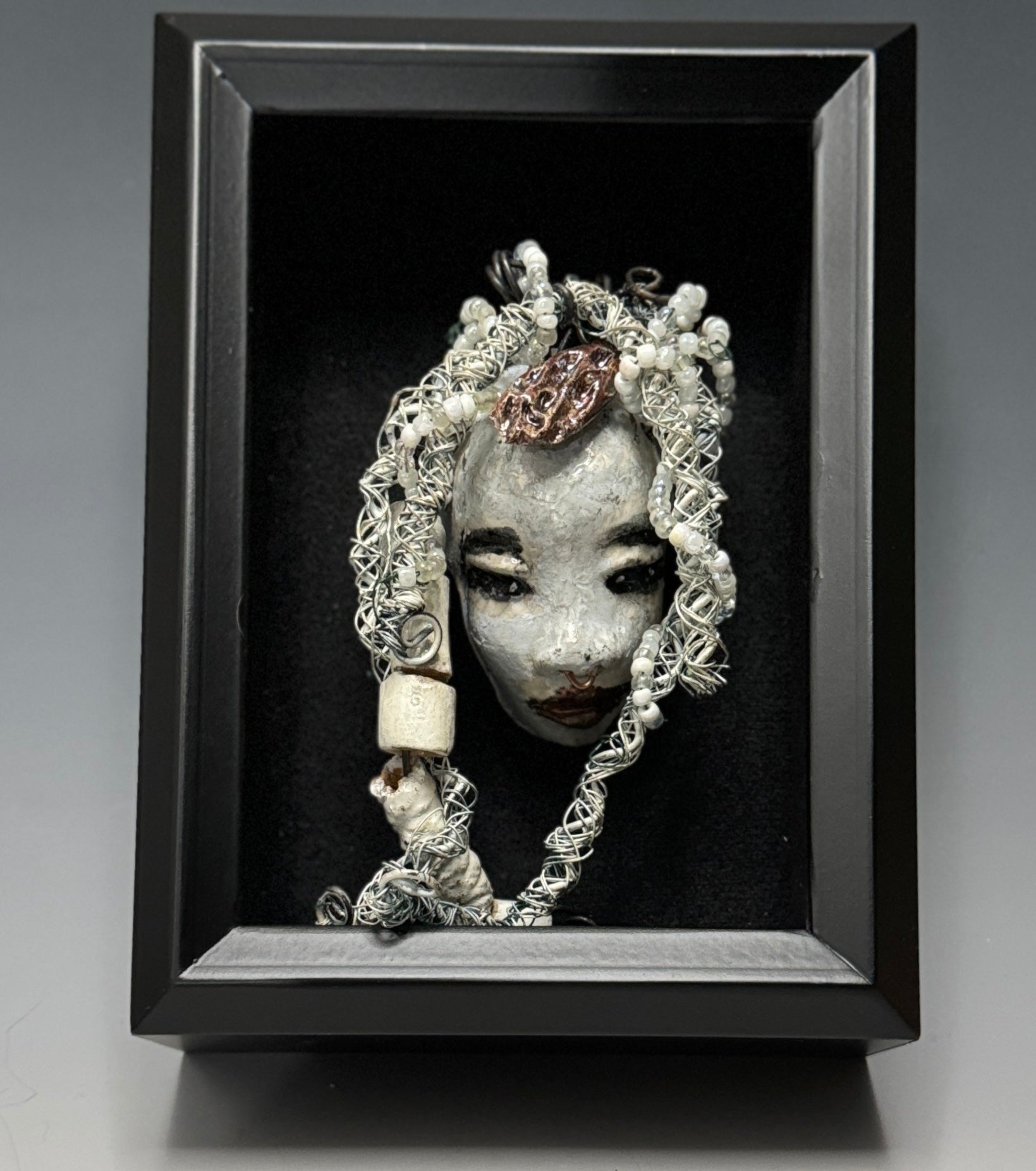Faye is an absolutely stunning 4" x 4", 4.2 oz. Raku-fired mask with a white complexion, intricate beaded hair, and a one-of-a-kind portrait setting of a majestic tree. She's sure to make a statement indoors or outdoors - an artful gift for nature admirers and décor fans alike!