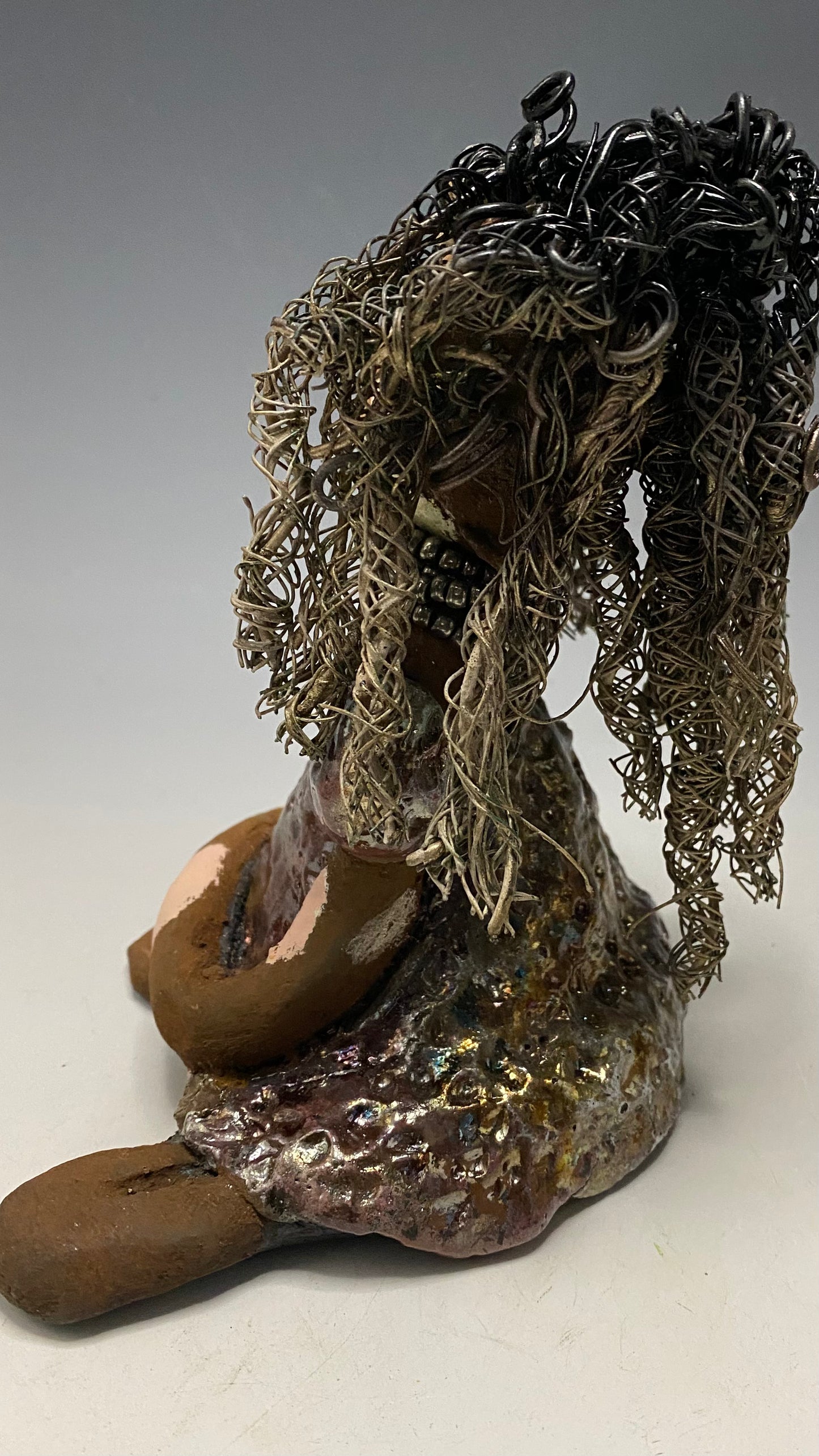 Anita stands 6.5" x 6" x 3" and weighs 1.3 lbs., with vitiligo. She loves the skin she's in! Her lips are painted with a warm ruby red, and long twisted white and gold wire locs that extend to her waist give her a unique style. Her dress is finished with a copper-antique glaze and over 75 feet of 16 and 24 gauge wire. Her bright eyes evoke a sense of hope. Add Anita to your family and she'll sure to be a conversation starter. Have questions? Ask away!