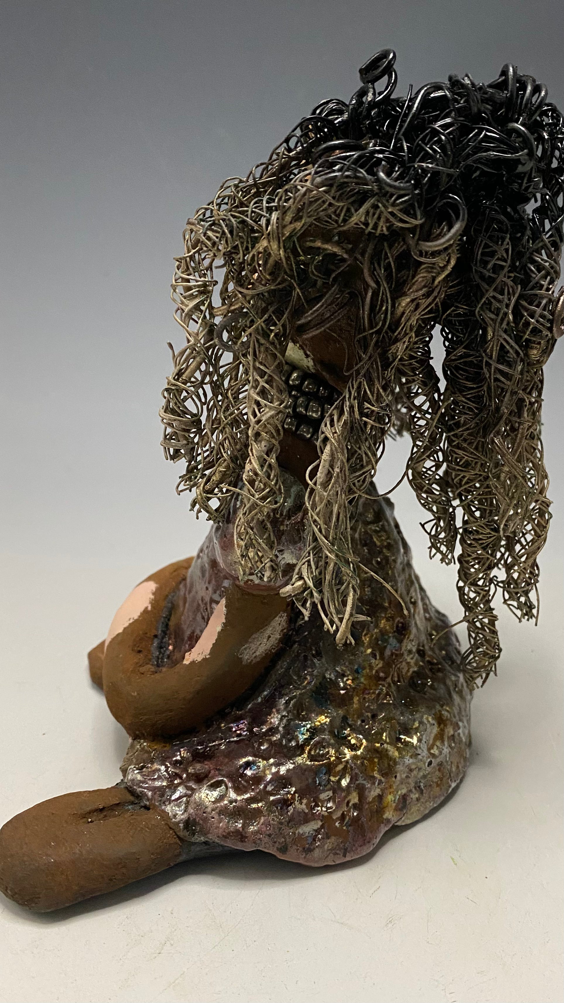 Anita stands 6.5" x 6" x 3" and weighs 1.3 lbs., with vitiligo. She loves the skin she's in! Her lips are painted with a warm ruby red, and long twisted white and gold wire locs that extend to her waist give her a unique style. Her dress is finished with a copper-antique glaze and over 75 feet of 16 and 24 gauge wire. Her bright eyes evoke a sense of hope. Add Anita to your family and she'll sure to be a conversation starter. Have questions? Ask away!