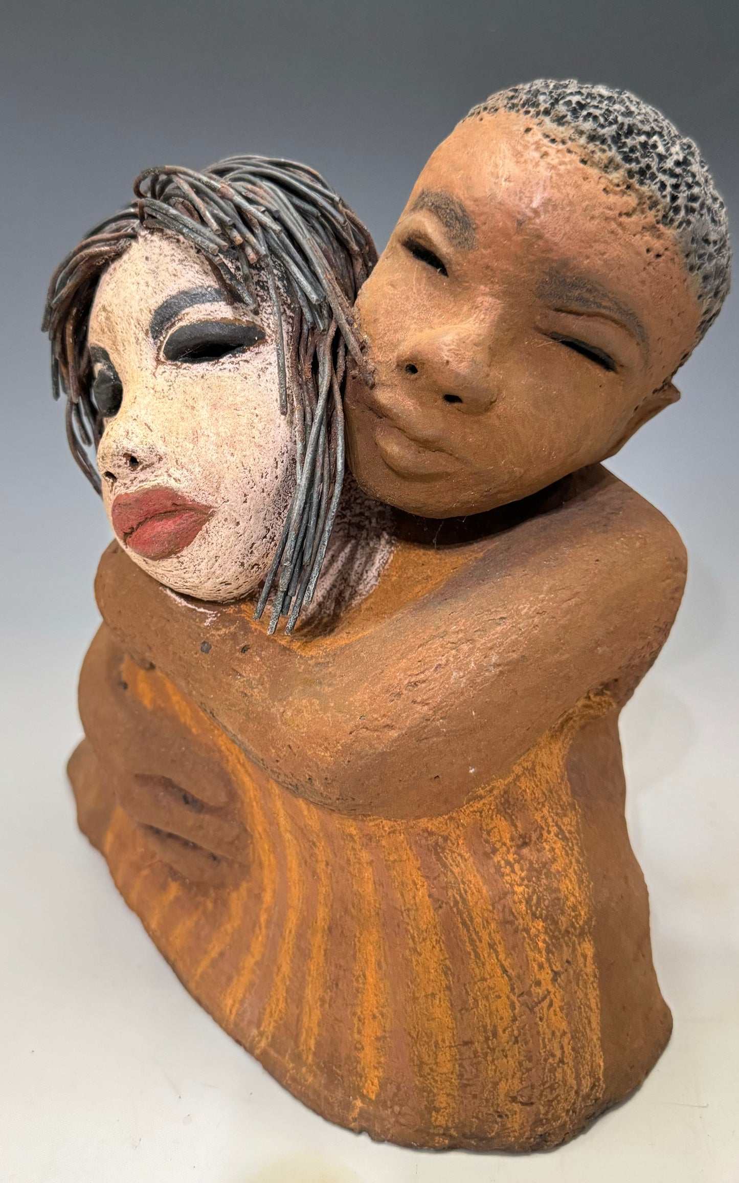 What a Sweet Couple... Is she Expecting?! I Love You More stands 10" x 9" x 5" and weighs 5.04 lbs. It has a honey brown complexion, with long loving arms that interlock in affection. Her hair is wire while his is made of clay, making I Love You More unique and perfect for any home.