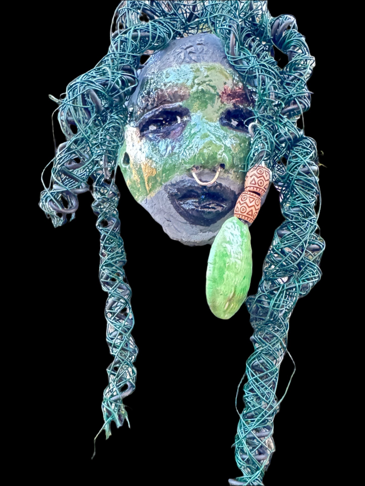 Introducing Nala, a unique raku fire mask made with a stunning mixture of 24 and 16 gauge wire and adorned with detailed blue tribal beads. This 4 x 6" piece features over 15 feet of wire and can be proudly displayed on a solid black or white surface. For a more striking display, try Nala against a backdrop of lush, verdant trees.