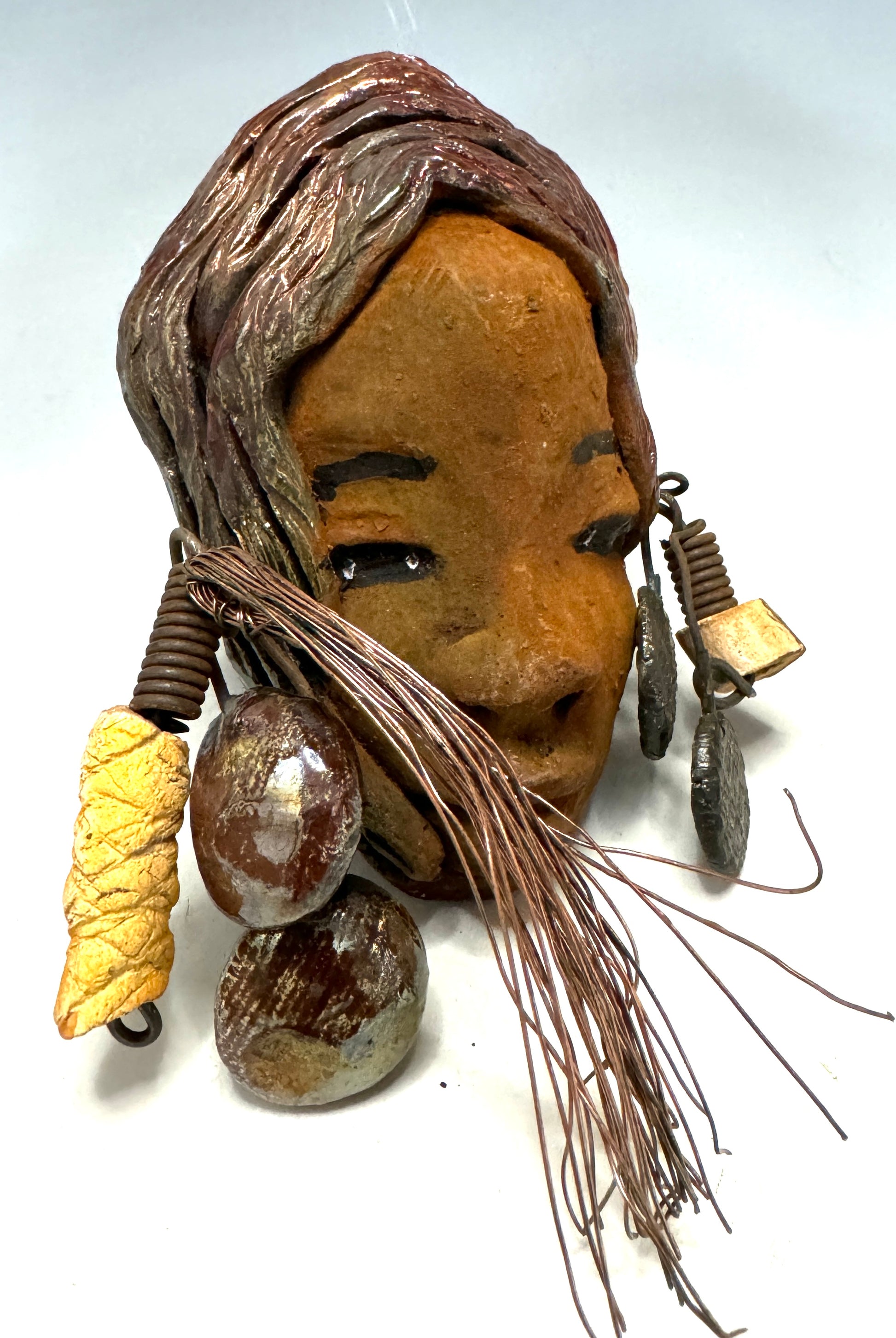 Marci boasts a beautiful honey-brown complexion, standing 5" x 7"  weighs 6.2 ozs. and embellished with coils of wire and hand-made beads. Her hair is graced with a copper glaze and was photographed outside amongst the trees. But of course, she will look fantastic no matter where you decide to place her.