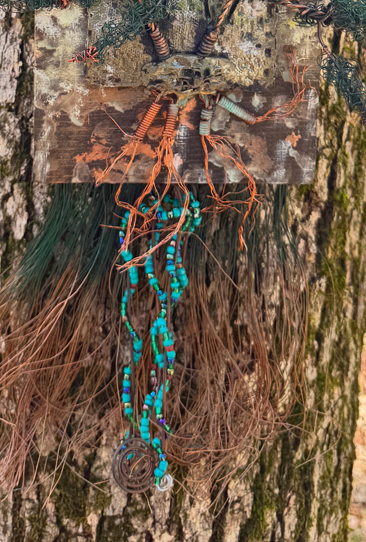 Indulge in the enchanting realm of Emerald Echoes with this unique mixed media landscape. Featuring a 20"x16" canvas adorned with a blend of 16- and 24-gauge wire and exquisite handmade Raku fire beads, it also boasts a stunning RAKU fired and hand-painted texture tile on a 7"x5" wooden base. Weighing 1.8 lbs, let yourself be transported to a balmy summer evening as the sun filters through the lush, verdant copper tip foliage.