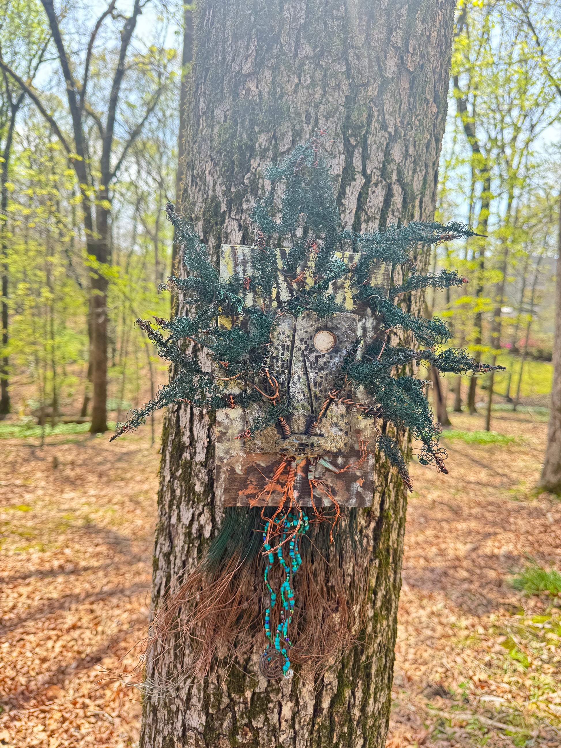 Indulge in the enchanting realm of Emerald Echoes with this unique mixed media landscape. Featuring a 20"x16" canvas adorned with a blend of 16- and 24-gauge wire and exquisite handmade Raku fire beads, it also boasts a stunning RAKU fired and hand-painted texture tile on a 7"x5" wooden base. Weighing 1.8 lbs, let yourself be transported to a balmy summer evening as the sun filters through the lush, verdant copper tip foliage.