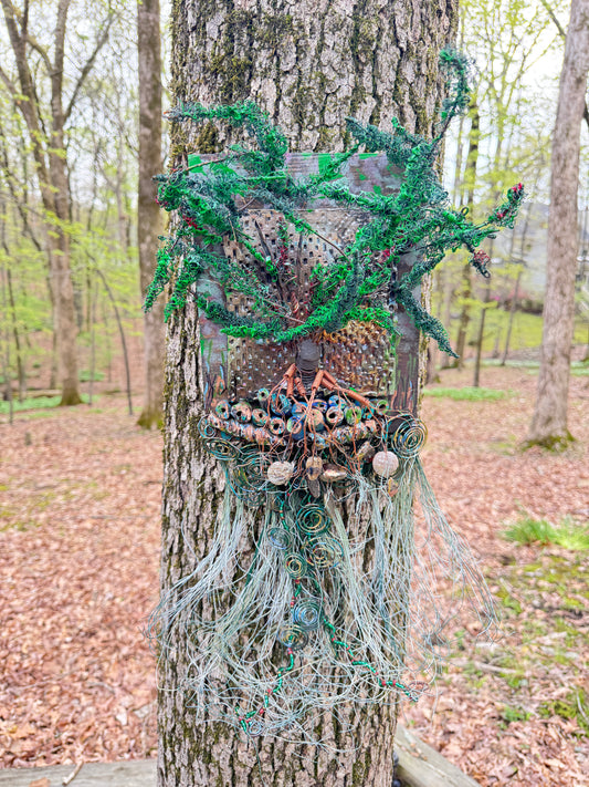 Explore the mesmerizing coil root of The Radiant Root, a mystical subterranean world showcased on a 20"x16" canvas embellished with a combination of 16- and 24-gauge wire and exquisite Raku fire beads, alongside a captivating RAKU fired and hand-painted texture tile resting on a 7"x5" wooden base, with a weight of 1.8 lbs. Immerse yourself in the vibrant shades of a summer sunset as the sunlight highlights the lush greenery.