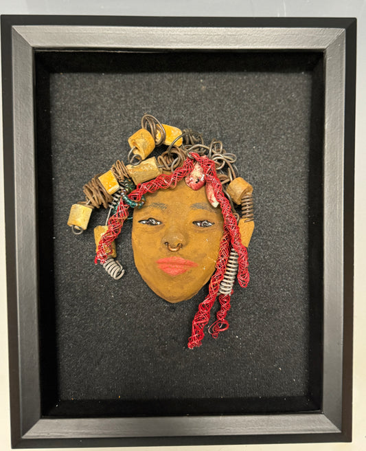 At 5" x 6" in size, Ola makes a stunning addition to walls, trees, and shadow boxes. His signature red braided hair is ornamented with handcrafted Raku beads, while his skin has a warm honey brown hue. Each piece is equipped with over 20 feet of top-notch 16 & 24-gauge wire in the hair. This fashionable sculpture will bring a modern flair to any room - simply place it in a shadow box and enjoy!