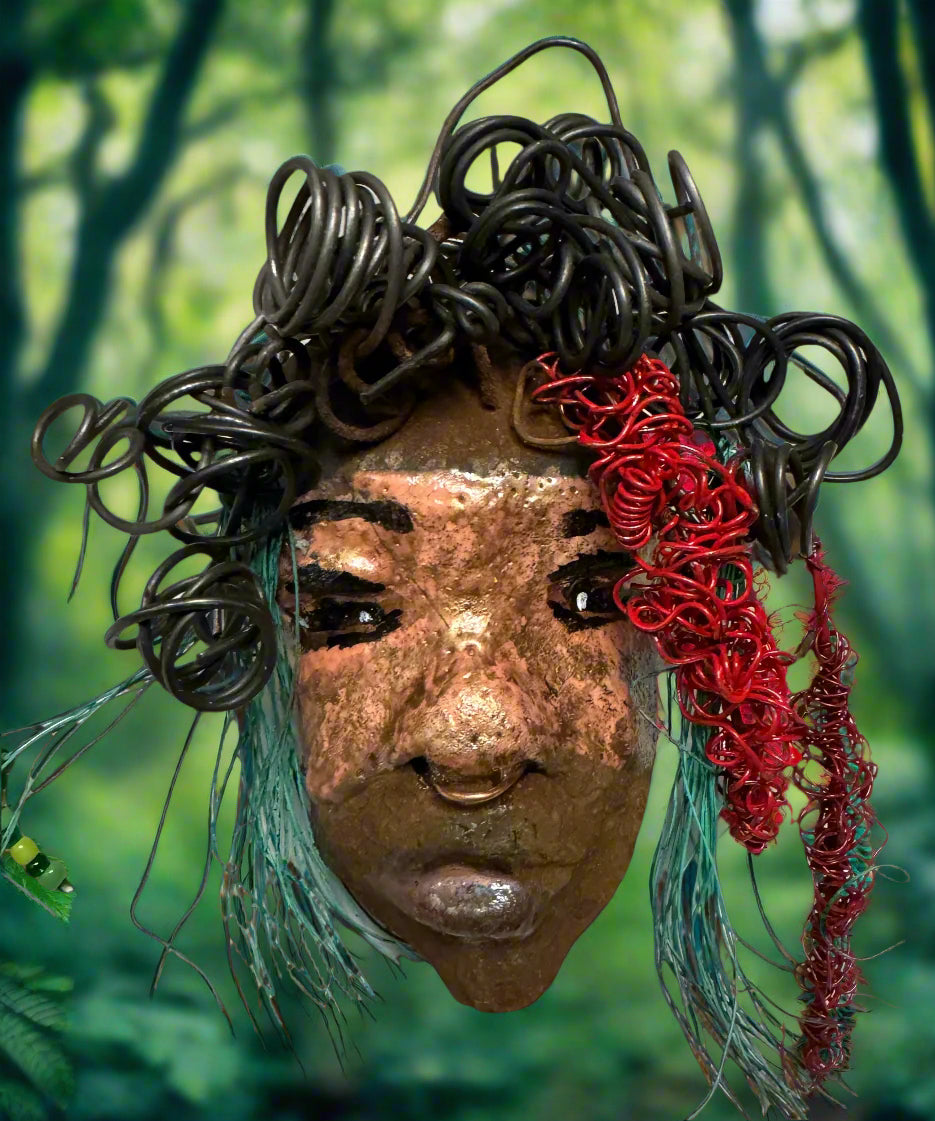 Dakari is an eye-catching two tone tribal raku mask, measuring 4 x 7" and weighing 6 oz. This mask is finished with a stunning blue  and red hair. Dakari also features a copper nose ring. Shadowbox is not included.