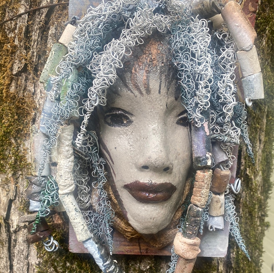 Summer has a white complexion and ruby red lips! She is 6”x 8”" and weighs 2.1 lbs. Summer has over 30 handmade raku fired beads. She has over 80 feet of coiled 16 and 24 gauge wire hair.