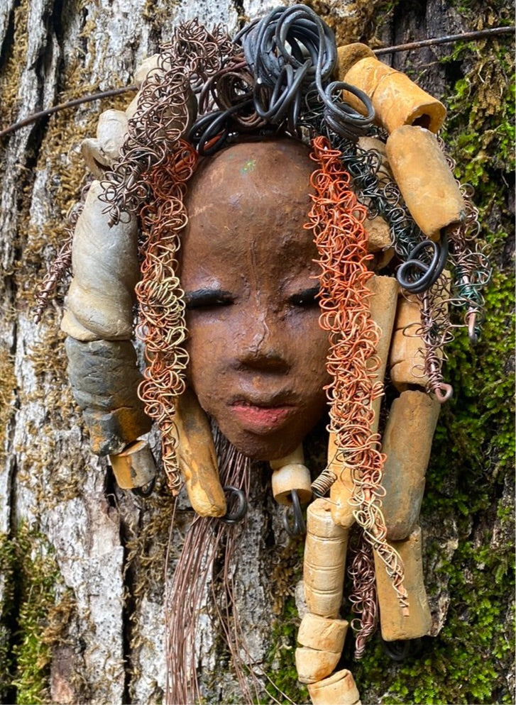Yembe is 4”x6 ” and weighs 7ozs. She has a brown complexion. Yembe has big hair with several spiral coils handmade Raku beads. Over 30 ft of hand twisted 16 and 24 gauge wire!