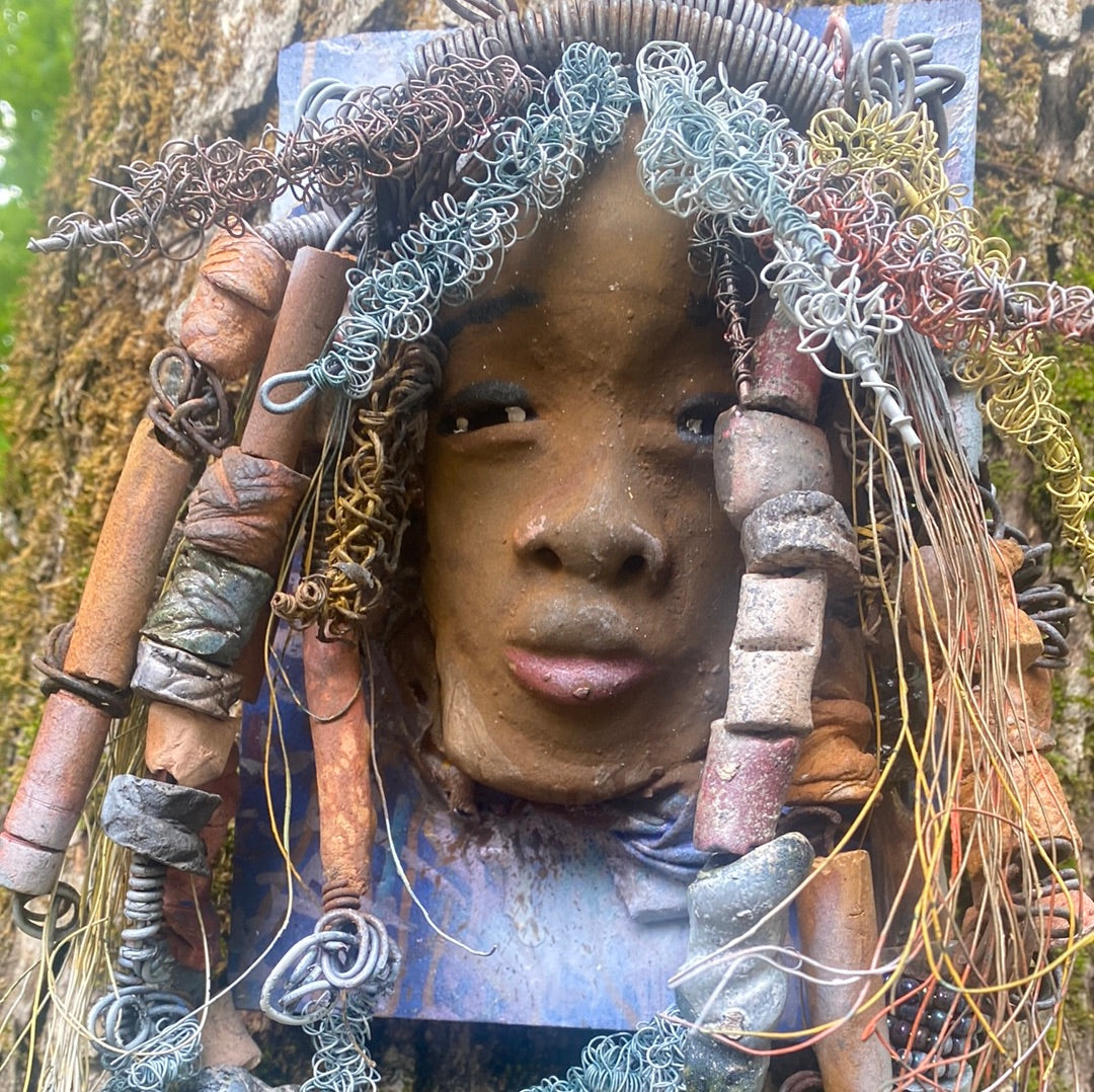 Valarie is mounted 5” x 8 x 1 and weighs 1.13 lbs. She has a contagious smile. Valarie face has a lovely honey brown complexion. She has over 20 handmade raku fired beads Over 60 feet of 16 and 24 gauge twisted wire for hair!