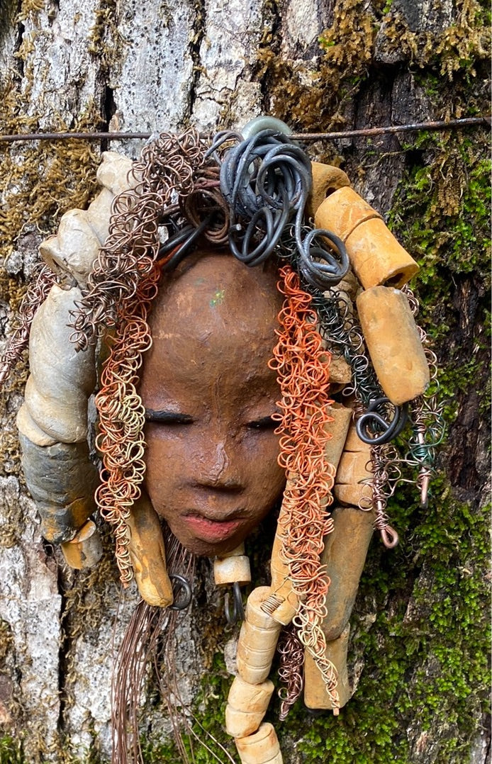 Yembe is 4”x6 ” and weighs 7ozs. She has a brown complexion. Yembe has big hair with several spiral coils handmade Raku beads. Over 30 ft of hand twisted 16 and 24 gauge wire!