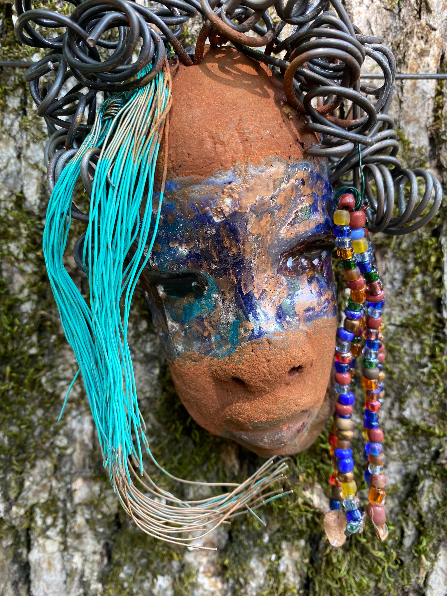 G.G features a two-tone copper-brown textured complexion with discernible red-brown lips. Boasting dimensions of 5"x5" and a weight of 6 oz., G.G includes beads and over 10 feet of 24- and 16-gauge coiled wire hair. Position G.G in a special area and keep secure.