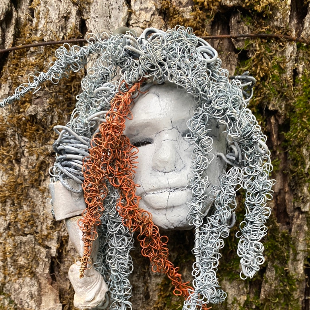 Wendy has an off white complexion with off white lips. She is 6”x 8” and weighs 10 ozs. Wendy has handmade raku fired beads. Wendy has over 70 feet of coiled 24 and 16 gauge wire hair.