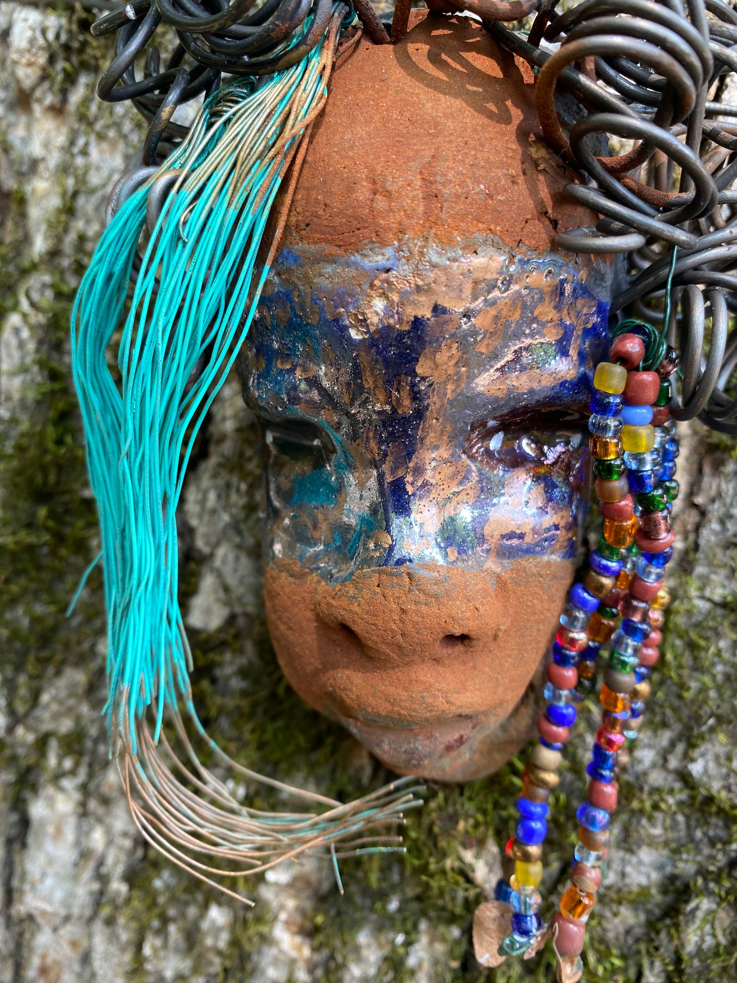 G.G features a two-tone copper-brown textured complexion with discernible red-brown lips. Boasting dimensions of 5"x5" and a weight of 6 oz., G.G includes beads and over 10 feet of 24- and 16-gauge coiled wire hair. Position G.G in a special area and keep secure.