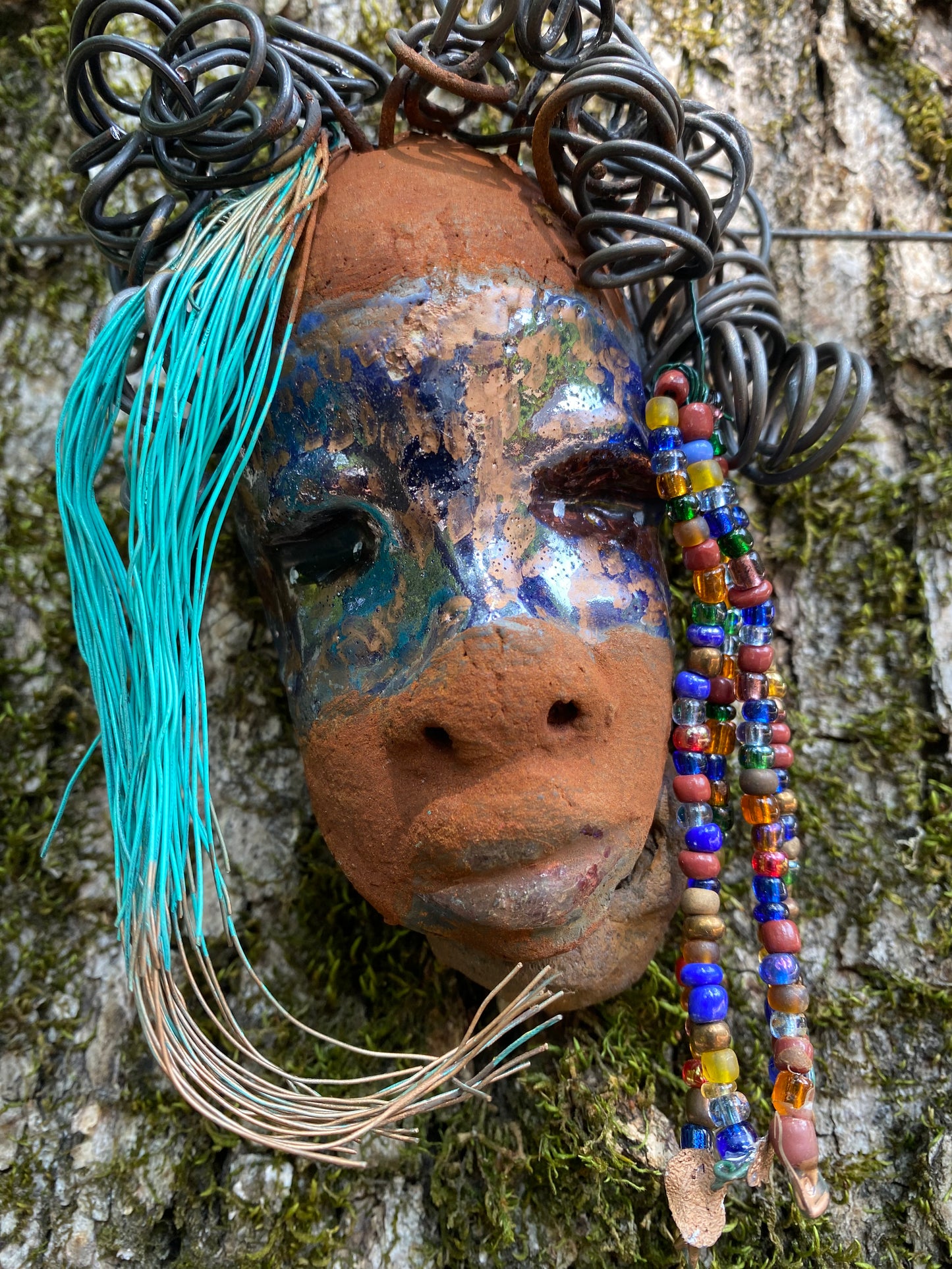 G.G features a two-tone copper-brown textured complexion with discernible red-brown lips. Boasting dimensions of 5"x5" and a weight of 6 oz., G.G includes beads and over 10 feet of 24- and 16-gauge coiled wire hair. Position G.G in a special area and keep secure.