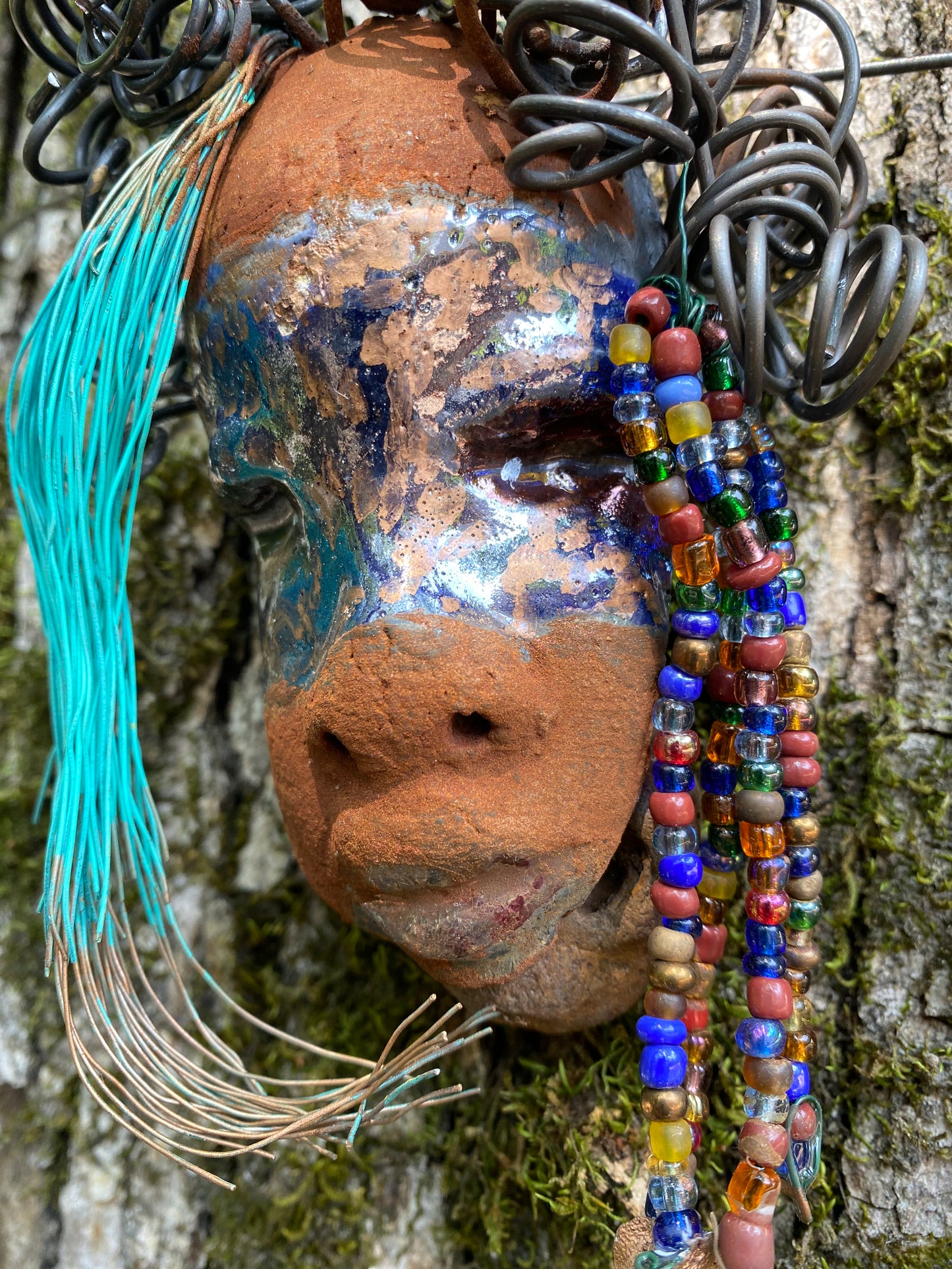 G.G features a two-tone copper-brown textured complexion with discernible red-brown lips. Boasting dimensions of 5"x5" and a weight of 6 oz., G.G includes beads and over 10 feet of 24- and 16-gauge coiled wire hair. Position G.G in a special area and keep secure.