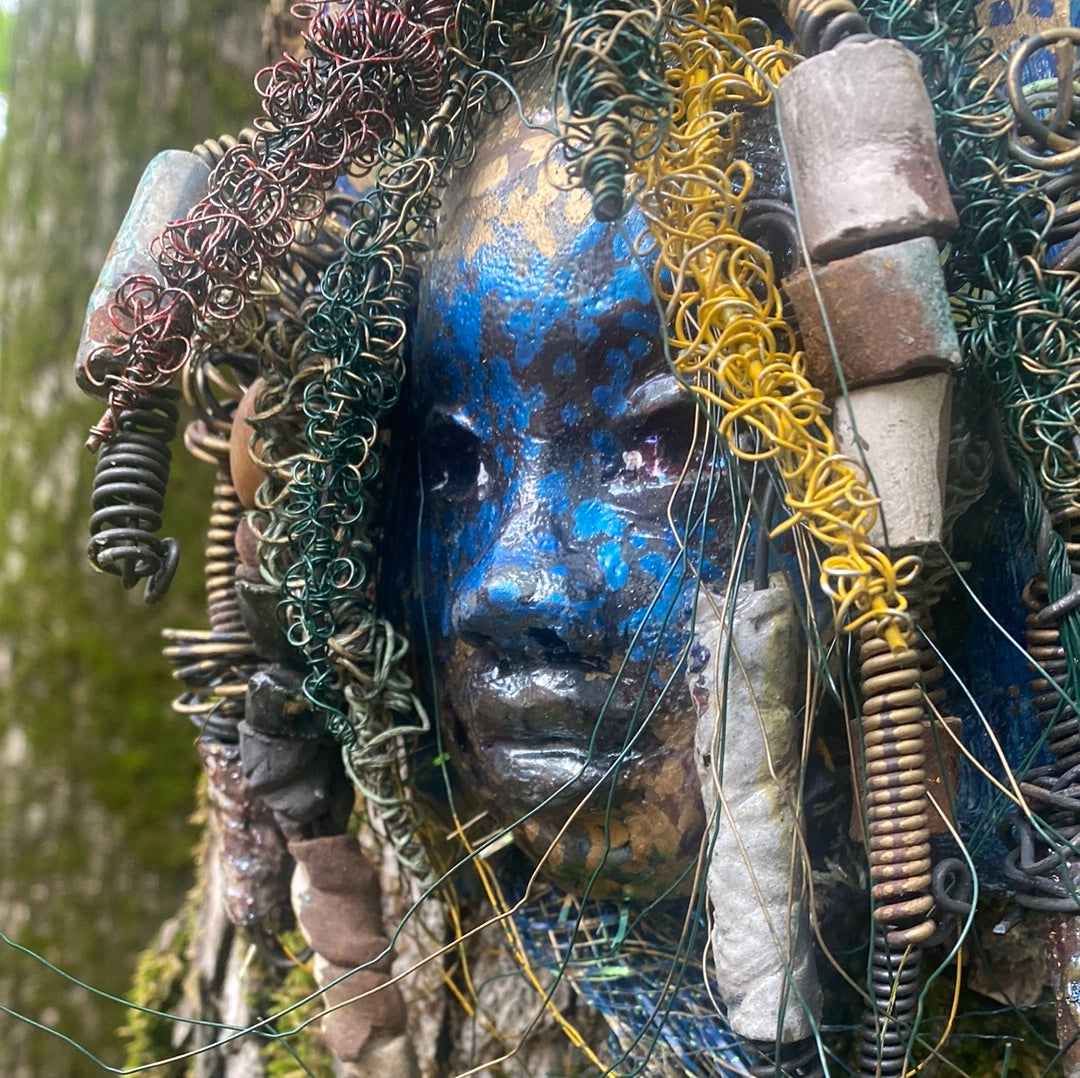 Urbi is one of a new 2023 series of tribal masks that are mounted on wood.