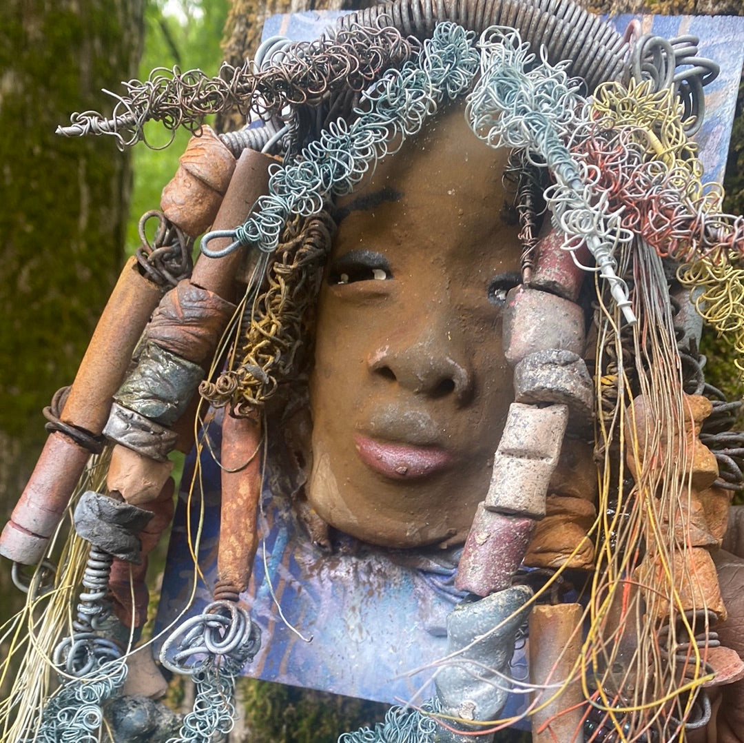 Valarie is mounted 5” x 8 x 1 and weighs 1.13 lbs. She has a contagious smile. Valarie face has a lovely honey brown complexion. She has over 20 handmade raku fired beads Over 60 feet of 16 and 24 gauge twisted wire for hair!