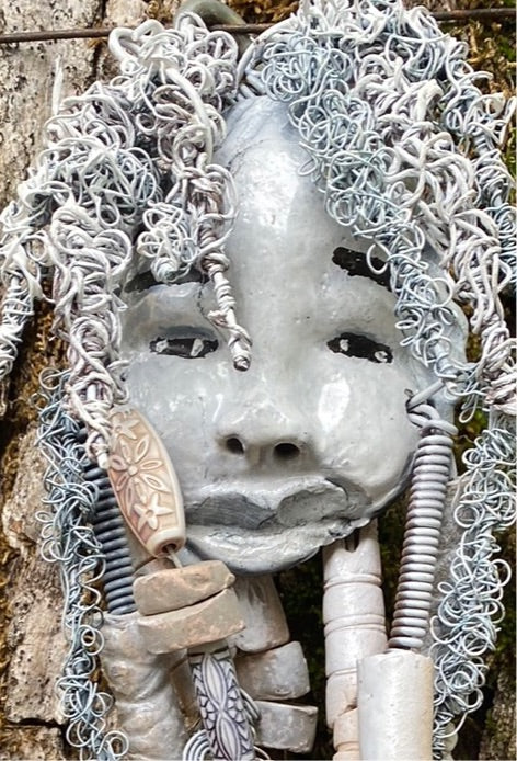 Wei has an off white complexion with off white lips. She is 6”x 8” and weighs 10 ozs. Wei has more than 10 handmade raku fired beads. Wei has over 70 feet of coiled 24 and 16 gauge wire hair.