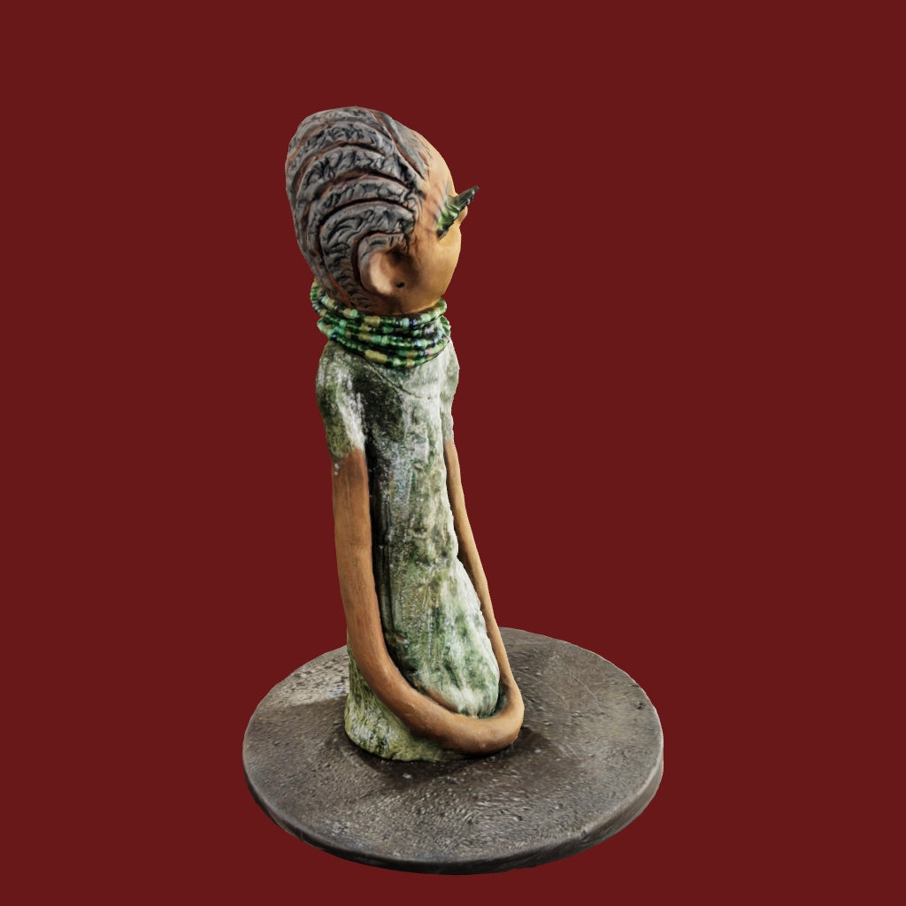 Marissa stands tall at 11.5"x3"x3.5", weighing only 2.5 lbs. Her beauty is captivating; honey brown skin, reddish brown lips, and a short black clay braid. Her dress is uniquely adorned with vibrant metallic copper-green glaze, and her eyelashes are the longest in the world. Her green eyes look up with a hope of joining your family.
