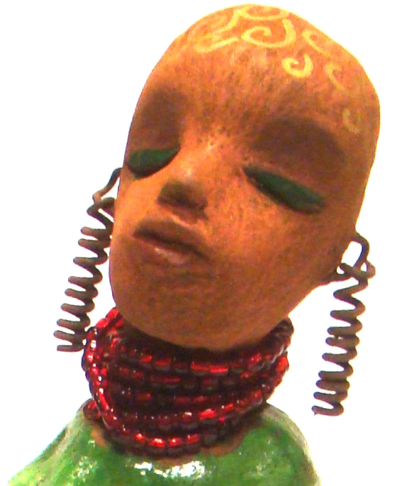Amaya stands 10" x 6" x 2.5" and weighs 1.03 lbs. She has a lovely honey brown complexion. Her hair is drawn with spiral gold ink. Amaya long loving arms rest beside her alligator green dress. She wears a strand of ruby red beads with spiral wire ear rings. Amaya is a sophisticated lady that will grace your home. Free Shipping!