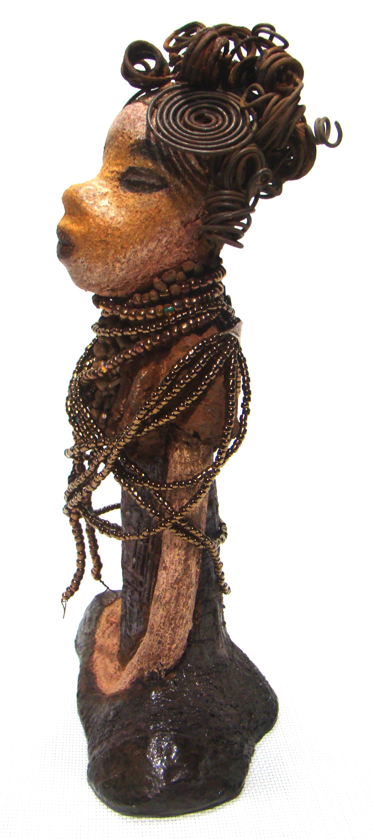Cardi stands 11" x 5.5" x 3" and weighs 1.14 lbs. She has an awesome two tone honey beige complexion. Cardi wears a dark metallic copper dress with a chocolate ruffle scarf. She wears a multitude of amber colored hand strung beads. I do believe Cardi would like it if you gave her a space in your home!