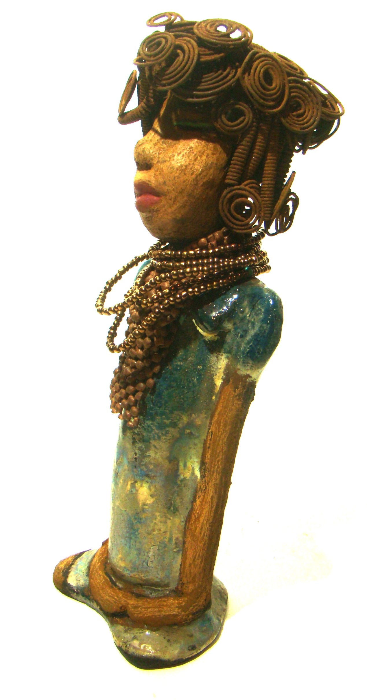 Sherri stands 13' x 4" x 2.5" and weighs 3.05 lbs. She has over 25 feet of wire curls and coils. Sherri has a sweet honey brown complexion. Her dress is a metallic multi colored green with an amber beaded necklace and scarf. Sherri has the familiar long loving arms at her side.