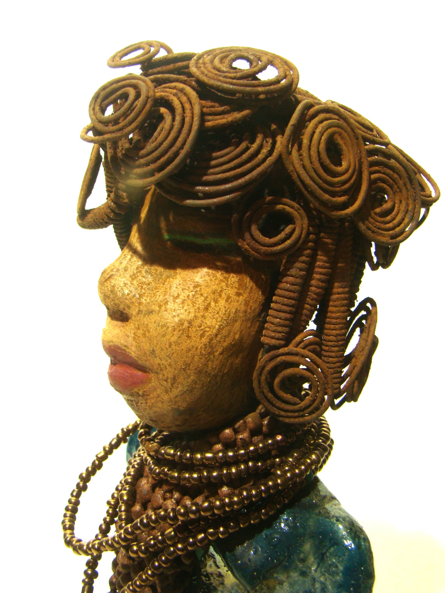 Sherri stands 13' x 4" x 2.5" and weighs 3.05 lbs. She has over 25 feet of wire curls and coils. Sherri has a sweet honey brown complexion. Her dress is a metallic multi colored green with an amber beaded necklace and scarf. Sherri has the familiar long loving arms at her side.